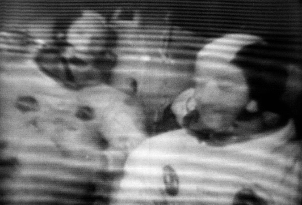 S69-26148 (6 March 1969) --- This photograph from the second live television transmission from Apollo 9 was made early Thursday afternoon on the fourth day in space. Though of poor quality, this view shows the interior of the Lunar Module "Spider" with astronauts James A. McDivitt (foreground) and Russell L. Schweickart at their crew stations. McDivitt is the Apollo 9 commander; and Schweickart is the lunar module pilot. At this moment Apollo 9 was orbiting Earth with the Command and Service Modules docked nose-to-nose with the Lunar Module. Astronaut David R. Scott, command module pilot, remained at the controls in the Command Module "Gumdrop" while the other two astronauts checked out the Lunar Module. McDivitt and Schweickart moved into the Lunar Module from the Command Module by way of the docking tunnel.