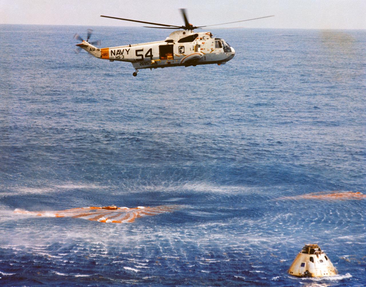 S69-27919 (13 March 1969) --- Immediately after splashdown a recovery helicopter from the USS Guadalcanal hovers over the Apollo 9 spacecraft. Still inside the Command Module (CM) are astronauts James A. McDivitt, David R. Scott, and Russell L. Schweickart. Splashdown occurred at 12:00:53 p.m. (EST), March 13, 1969, only 4.5 nautical miles from the USS Guadalcanal, the prime recovery ship, to conclude a successful 10-day Earth-orbital mission in space.