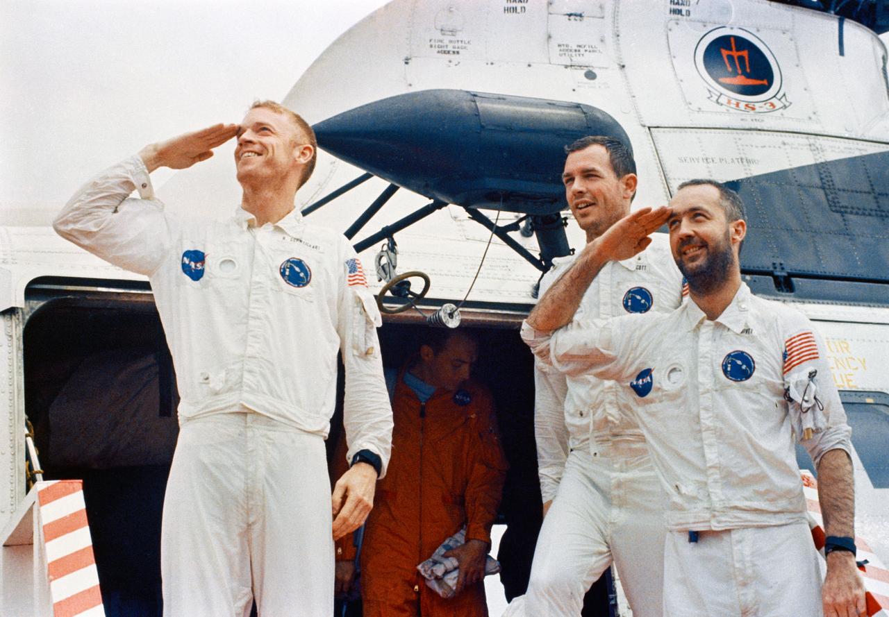 S69-27921 (13 March 1969) --- The Apollo 9 crewmen arrive aboard the USS Guadalcanal as they step from a helicopter to receive a red-carpet welcome. Two of the crewmen salute the crowd of newsmen, Navy and NASA personnel gathered to greet them. Left to right, are astronauts Russell L. Schweickart, David R. Scott, and James A. McDivitt. Splashdown occurred at 12:00:53 p.m. (EST), March 13, 1969, only 4.5 nautical miles from the USS Guadalcanal, prime recovery ship, to conclude a successful 10-day Earth-orbital space mission. Photo credit: NASA