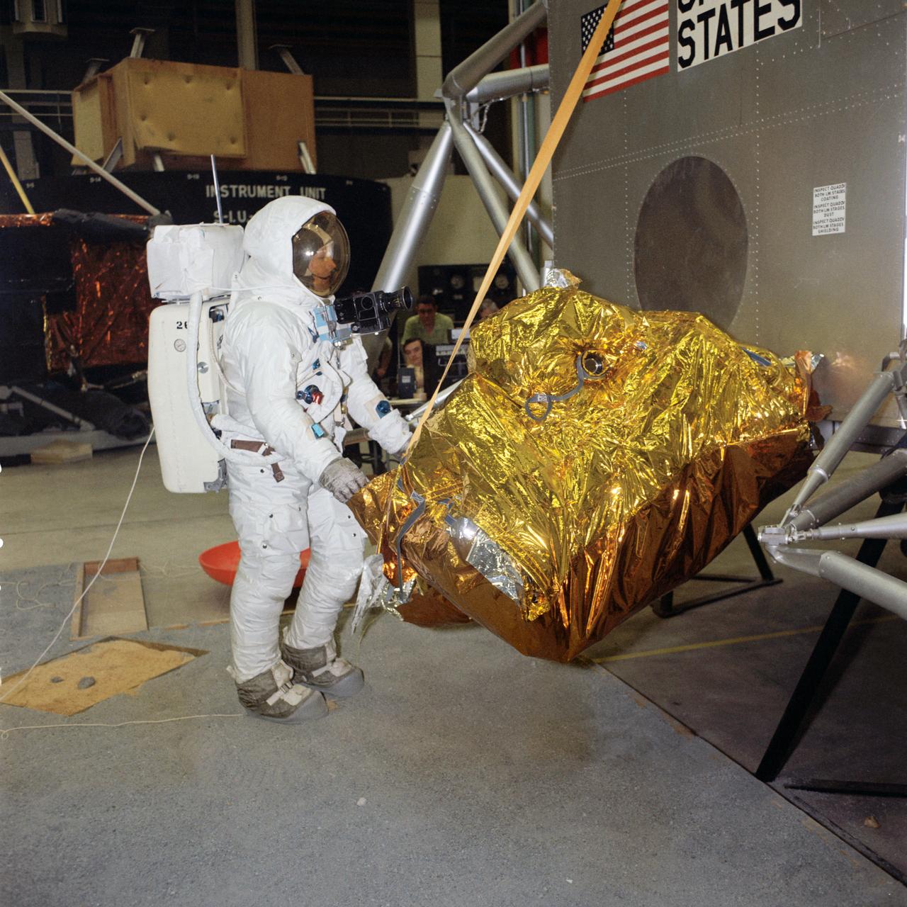 S69-31060 (18 April 1969) --- Suited astronaut Neil A. Armstrong, wearing an Extravehicular Mobility Unit (EMU), participates in lunar surface simulation training on April 18, 1969 in building 9, Manned Spacecraft Center (MSC). Armstrong is prime crew commander of the Apollo 11 lunar landing mission. Here, he is opening the Modularized Equipment Stowage Assembly ( MESA).