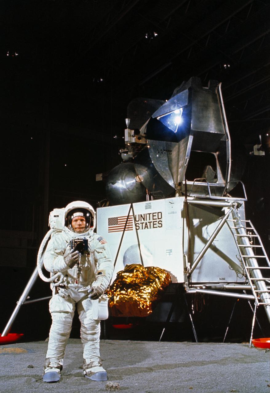S69-32240 (22 April 1969) --- Astronaut Neil A. Armstrong, wearing an Extravehicular Mobility Unit, participates in a simulation of deploying and using lunar tools on the surface of the moon during a training exercise in Building 9 on April 22, 1969. Armstrong is the commander of the Apollo 11 lunar landing mission. In the background is a Lunar Module mock-up.