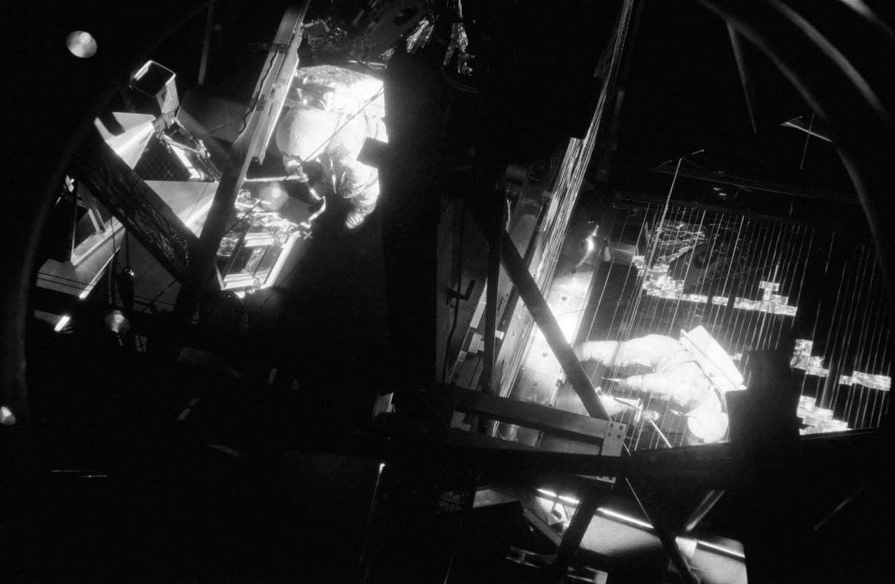 Astronaut Neil A. Armstrong, commander of the Apollo 11 lunar landing mission, is photographed during thermovacuum training in Chamber B of the Space Environment Simulation Laboratory, Building 32, Manned Spacecraft Center. He is wearing an Extravehicular Mobility Unit. The training simulated lunar surface vacuum and thermal conditions during astronaut operations outside the Lunar Module on the moon's surface. The mirror was used to reflect solar light.