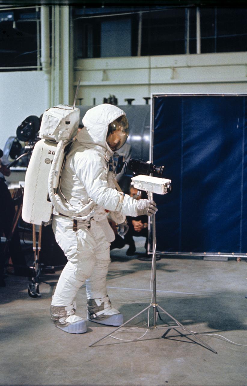 S69-33923 (April 1969) --- Astronaut Neil A. Armstrong, wearing an Extravehicular Mobility Unit (EMU), deploys a lunar surface television camera during lunar surface simulation training in Building 9, Manned Spacecraft Center (MSC).  Armstrong is the prime crew commander of the Apollo 11 lunar landing mission.