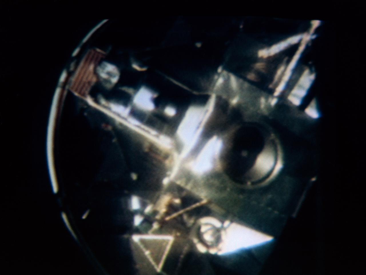 S69-33993 (18 May 1969) --- The Apollo 10 Lunar Module, still attached to the Saturn IVB stage, is seen in this color reproduction taken from the first television transmission made by the color television camera aboard the Apollo 10 spacecraft. This picture was made following CSM/LM-S-IVB separation, and prior to LM extraction from the S-IVB. The Command and Service Modules were making the docking approach to the LM/S-IVB. The circular object is the docking drogue assembly on the LM. Aboard the Command Module were astronauts Thomas P. Stafford, commander; John W. Young, command module pilot; and Eugene A. Cernan, lunar module pilot.