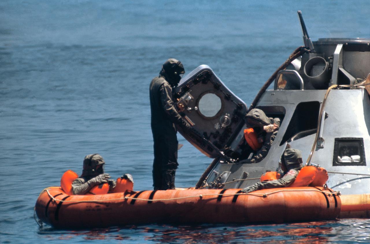 S69-34967 (24 May 1969) --- The third member of the prime crew of the Apollo 11 lunar landing mission egresses Apollo Boilerplate 1102 during water egress training in the Gulf of Mexico. The other two crewmen are in raft. Taking part in the training were astronauts Neil A. Armstrong, commander; Michael Collins, command module pilot; and Edwin E. Aldrin Jr., lunar module pilot. The three crewmen practiced donning and wearing biological isolation garments (B.I.G.) as a part of the exercise. The Manned Spacecraft Center (MSC) swimmer standing up, who assisted in the training, is also wearing a B.I.G.