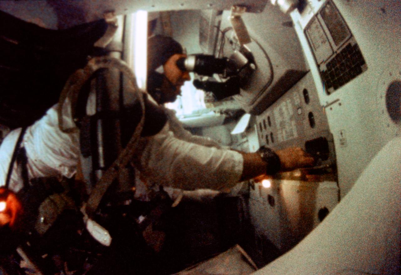 S69-35097 (21-27 Dec. 1968) --- Astronaut James A. Lovell Jr., Apollo 8 command module pilot, is seen at the Apollo 8 Spacecraft Command Module's Guidance and Navigation station during the Apollo 8 lunar orbit mission. This picture was taken from 16mm motion picture film.
