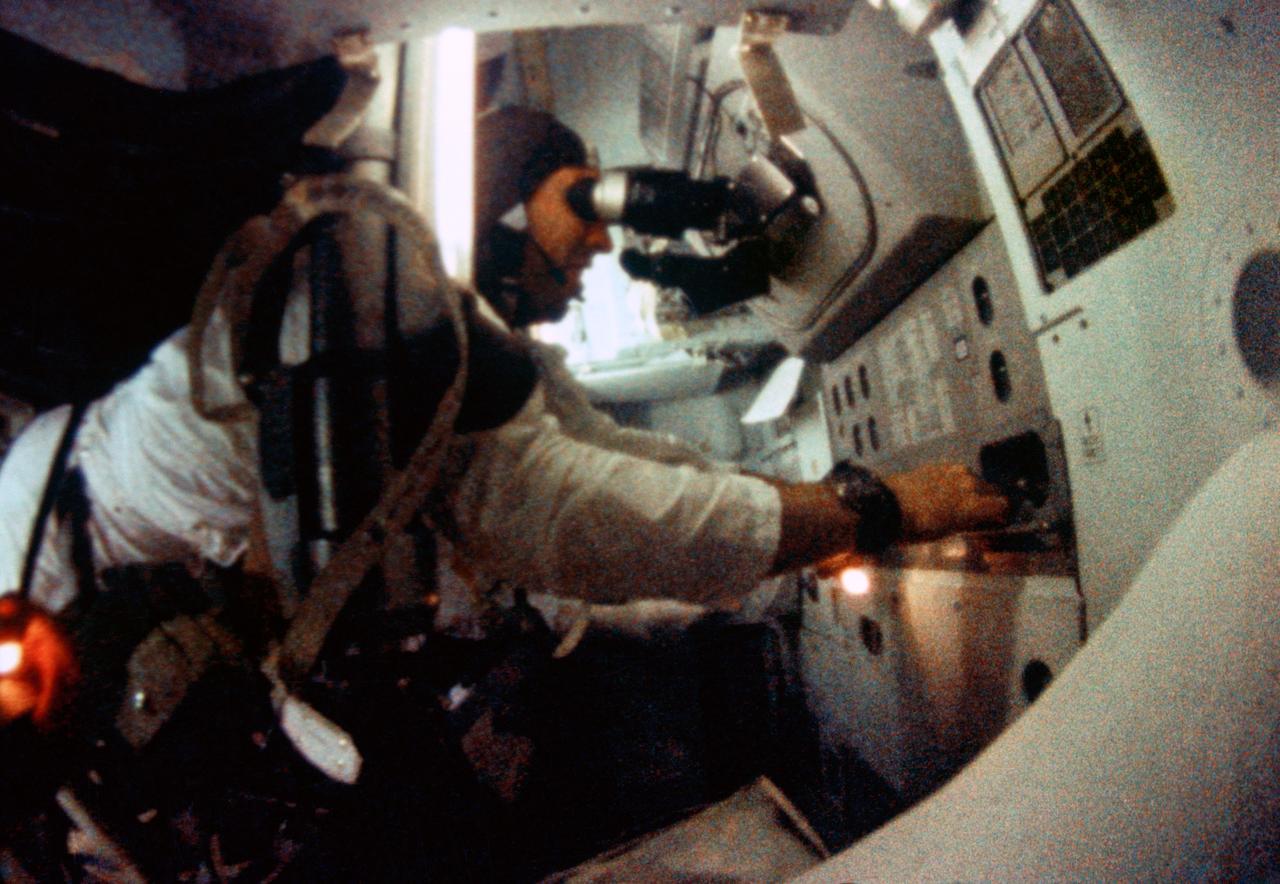 S69-35099 (21-27 Dec. 1968) --- Astronaut James A. Lovell Jr., Apollo 8 command module pilot, is seen at the Apollo 8 Spacecraft Command Module's Guidance and Navigation station during the Apollo 8 lunar orbit mission. This picture was taken from 16mm motion picture film.