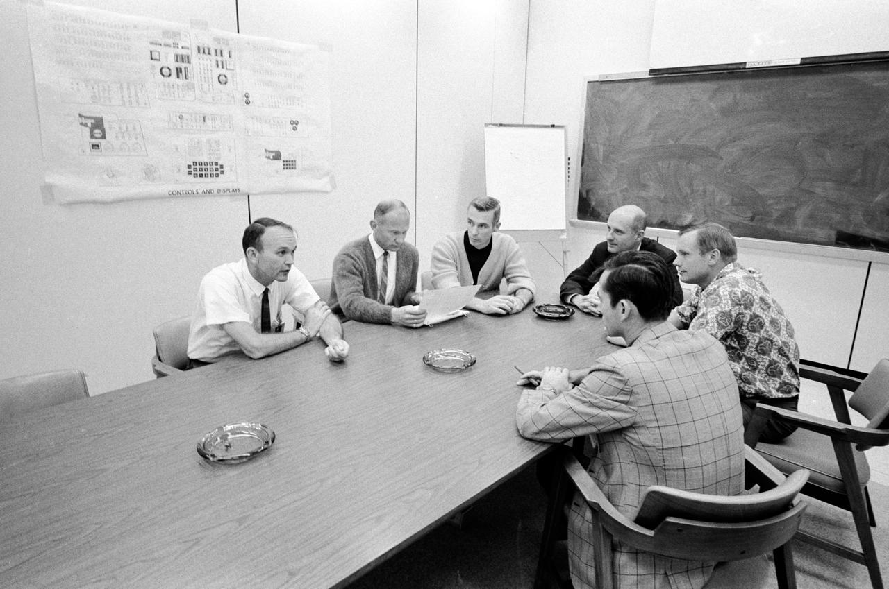 S69-35507 (June 1969) --- The prime crews of the Apollo 10 lunar orbit mission and the Apollo 11 lunar landing mission are photographed during an Apollo 10 postflight de-briefing session. Clockwise, from left, are astronauts Michael Collins, Apollo 11 command module pilot; Edwin E. Aldrin Jr., Apollo 11 lunar module pilot; Eugene A. Cernan, Apollo 10 lunar module pilot; Thomas P. Stafford, Apollo 10 commander; Neil A. Armstrong, Apollo 11 commander; and John W. Young, Apollo 10 command module pilot.