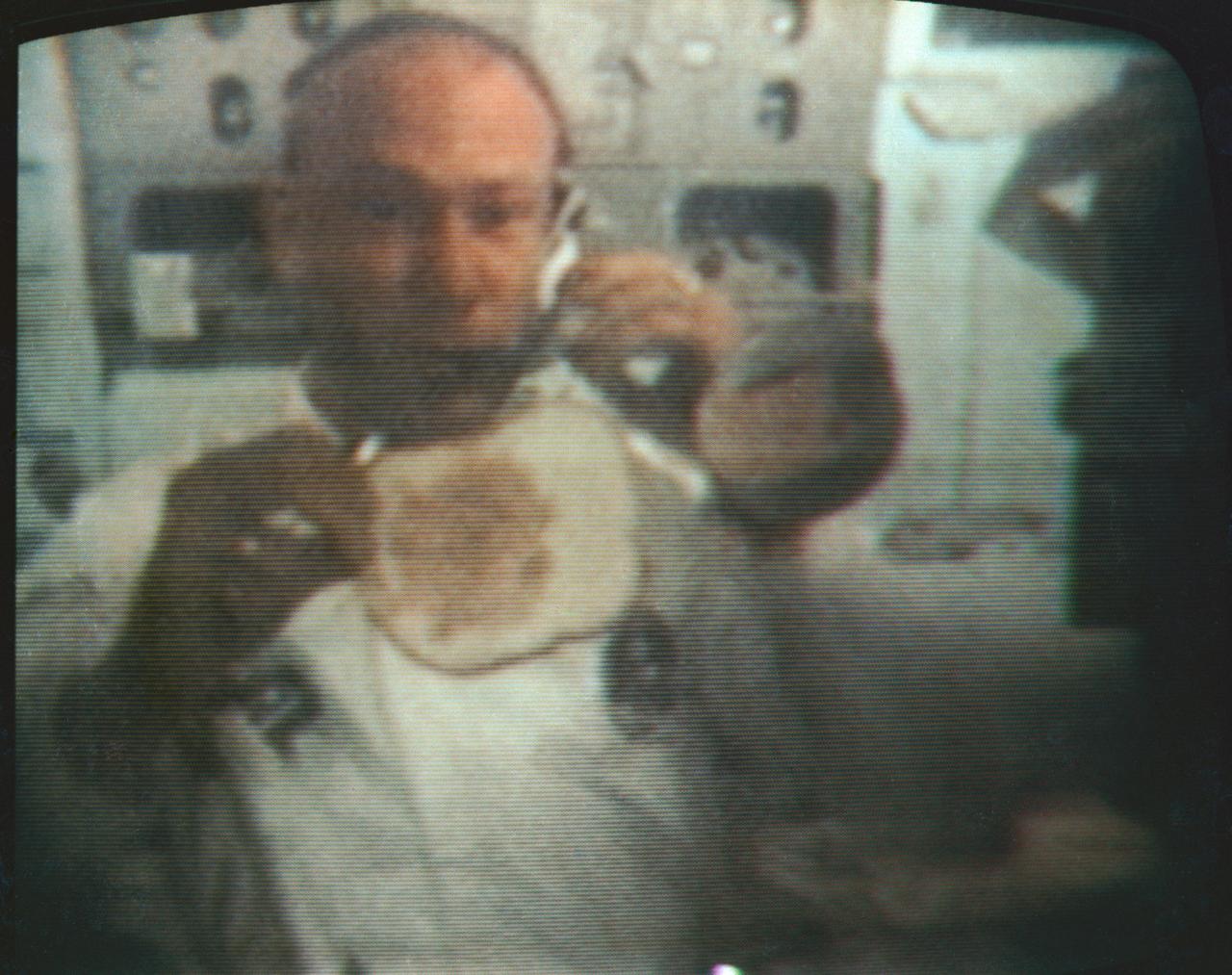 S69-39724 (22 July 1969) --- Astronaut Edwin E. Aldrin Jr., Apollo 11 lunar module pilot, performs for his Earth-bound television audience, in this color reproduction taken from a TV transmission, from the Apollo 11 spacecraft during its trans-Earth journey home from the moon. Aldrin illustrates how to make a sandwich under zero-gravity conditions.  When this picture was made, Apollo 11 was approximately 137,000 nautical miles from Earth, traveling at a speed of about 4,300 feet per second. Also, aboard the spacecraft were astronauts Neil A. Armstrong, commander; and Michael Collins, command module pilot.