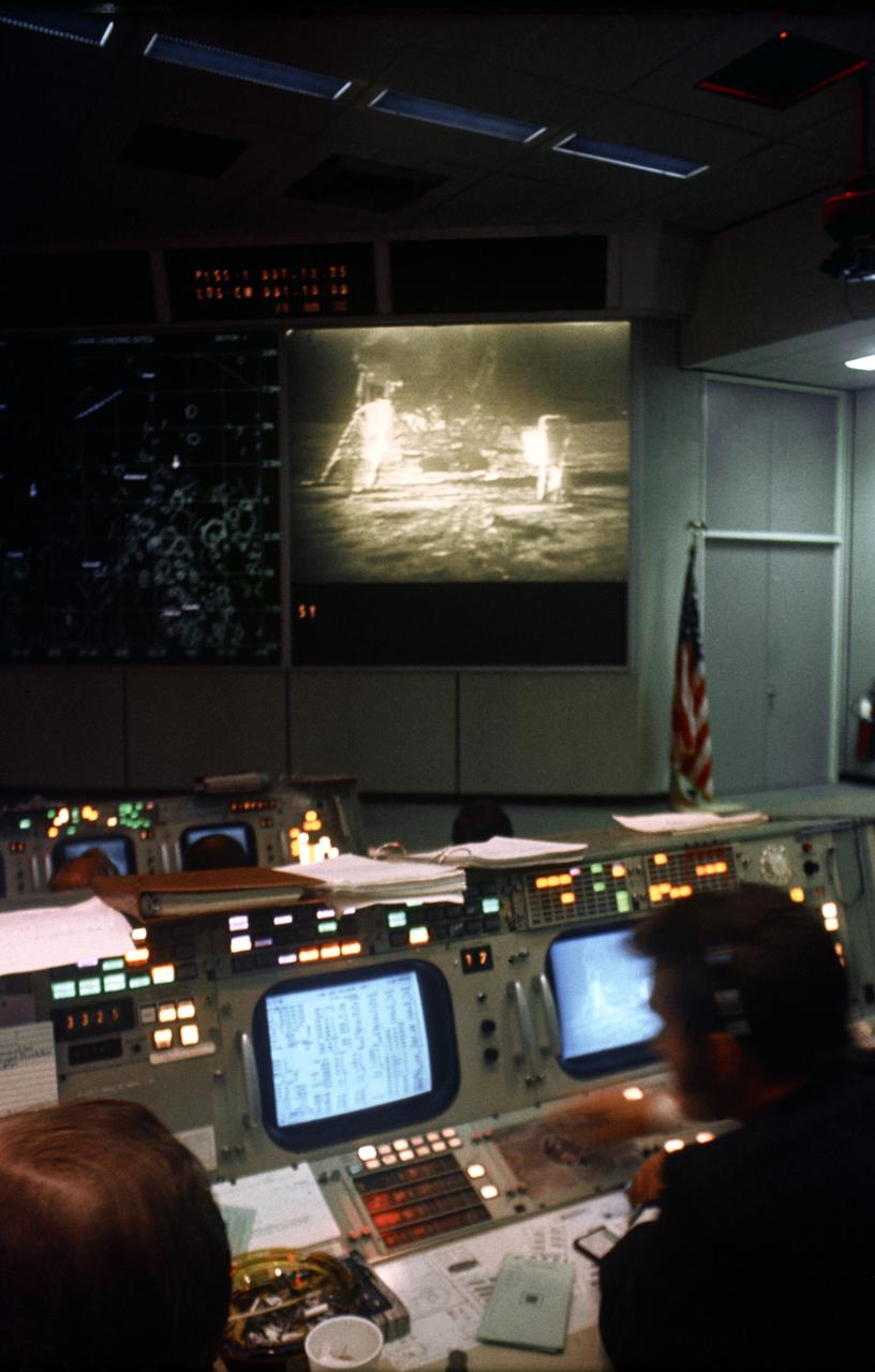 S69-39815 (20 July 1969) --- Interior view of the Mission Operations Control Room (MOCR) in the Mission Control Center (MCC) during the Apollo 11 lunar extravehicular activity (EVA). The television monitor shows astronauts Neil A. Armstrong and Edwin E. Aldrin Jr. on the surface of the moon.