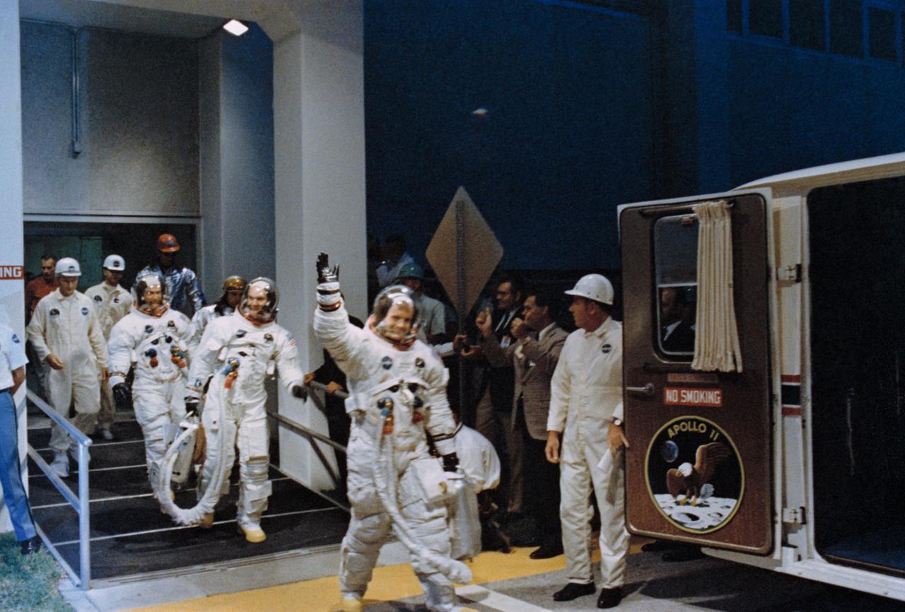 S69-39956 (16 July 1969) --- The crewmen of the Apollo 11 lunar landing mission leave the Kennedy Space Center's (KSC) Manned Spacecraft Operations Building (MSOB) during the prelaunch countdown. Astronauts Neil A. Armstrong, commander; Michael Collins, command module pilot; and Edwin E. Aldrin Jr., lunar module pilot, ride the special transport van over to Launch Complex 39A where their spacecraft awaited them. Liftoff was at 9:32 a.m. (EDT), July 16, 1969.