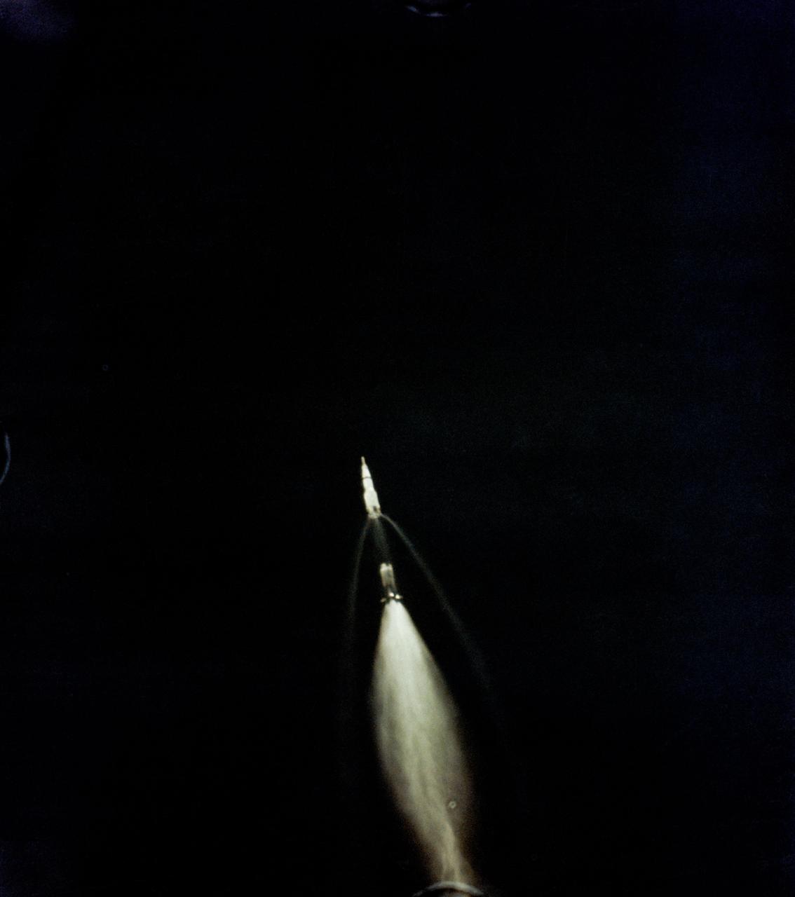 S69-39958 (16 July 1969) --- A 70mm Airborne Lightweight Optical Tracking System (ALOTS) camera, mounted in a pod on a cargo door of a U.S. Air Force EC-135N aircraft, photographed this event in the early moments of the Apollo 11 launch. The mated Apollo spacecraft and Saturn V second (S-II) and third (S-IVB) stages pull away from the expended first (S-1C) stage.  Separation occurred at an altitude of about 38 miles, some 55 miles downrange from Cape Kennedy.  The aircraft's pod is 20 feet long and 5 feet in diameter. The crew of the Apollo 11 lunar landing mission are astronauts Neil A. Armstrong, Michael Collins, and Edwin E. Aldrin Jr.