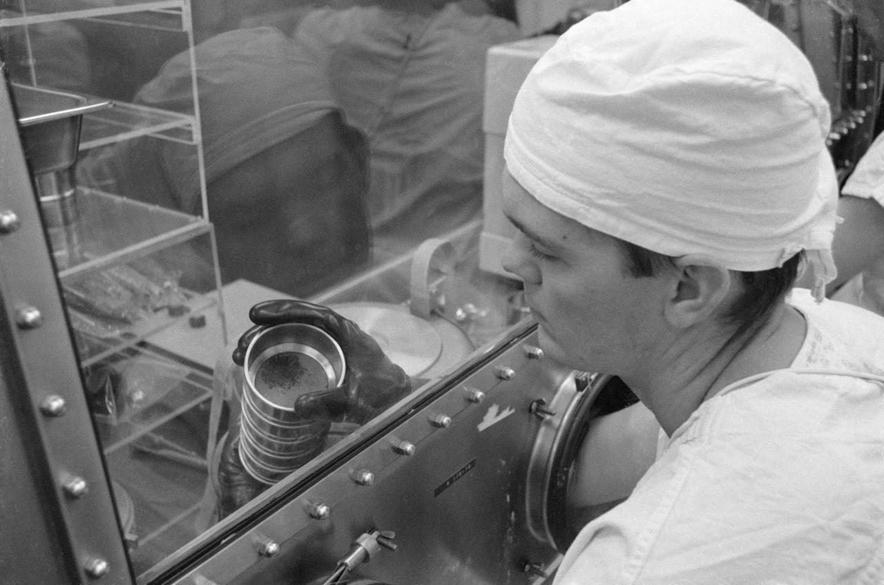 S69-40749 (July 1969) --- Dr. Grant Heikan, MSC and a Lunar Sample Preliminary Examination Team member, examines lunar material in a sieve from the bulk sample container which was opened in the Biopreparation Laboratory of the Lunar Receiving Laboratory. The samples were collected by astronauts Neil A. Armstrong and Edwin E. Aldrin Jr. during their lunar surface extravehicular activity on July 20, 1969.