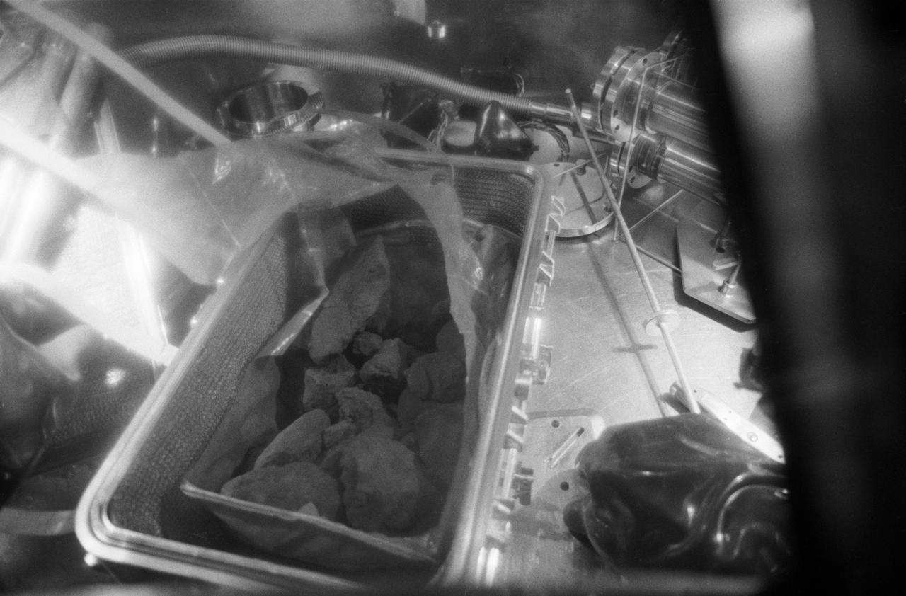 S69-45002 (26 July 1969) --- A close-up view of the lunar rocks contained in the first Apollo 11 sample return container. The rock box was opened for the first time in the Vacuum Laboratory of the Manned Spacecraft Center’s Lunar Receiving Laboratory, Building 37, at 3:55 p.m. (CDT), Saturday, July 26, 1969. The gloved hand gives an indication of size. This box also contained the Solar Wind Composition experiment (not shown) and two core tubes for subsurface samples (not shown). These lunar samples were collected by astronauts Neil A. Armstrong and Edwin E. Aldrin Jr. during their lunar surface extravehicular activity on July 20, 1969.
