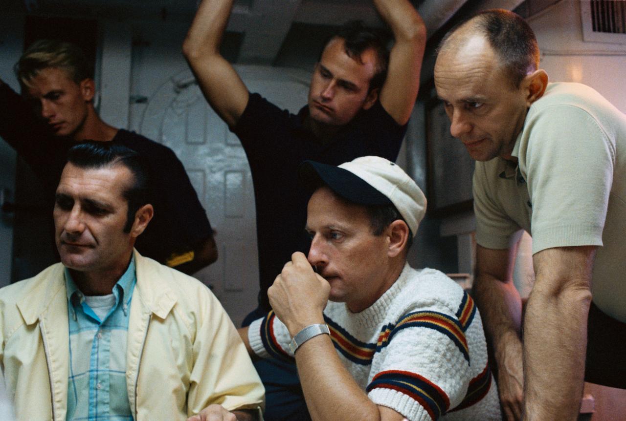 S69-52980 (1969) --- The three crewmen of the Apollo 12 lunar landing mission are briefed aboard the NASA Motor Vessel Retriever in preparation for water egress training in the Gulf of Mexico. Left to right, are astronauts Richard F. Gordon Jr., command module pilot; Charles Conrad Jr., commander; and Alan L. Bean, lunar module pilot. Two training personnel are in the background.