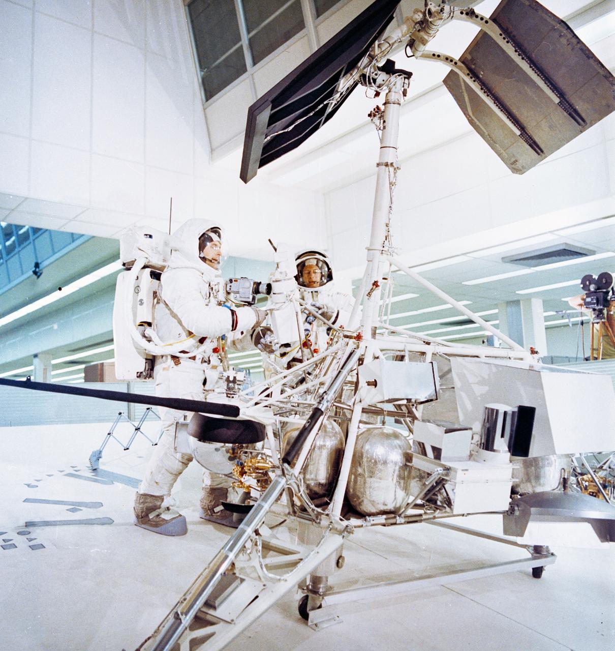 S69-55367 (6 Oct. 1969) --- Two members of the Apollo 12 lunar landing mission participate in lunar surface extravehicular activity (EVA) simulations in the Kennedy Space Center's (KSC) Flight Crew Training Building. Here, astronauts Charles Conrad Jr. (right), commander; and Alan L. Bean, lunar module pilot, simulate a photographic inspection of the unmanned Surveyor 3 spacecraft. The inspection of Surveyor 3, which has been resting on the moon's Ocean of Storms since April 1967, is an important objective of the Apollo 12 mission. Selected pieces will be cut from Surveyor 3 and brought back to Earth for scientific examination.