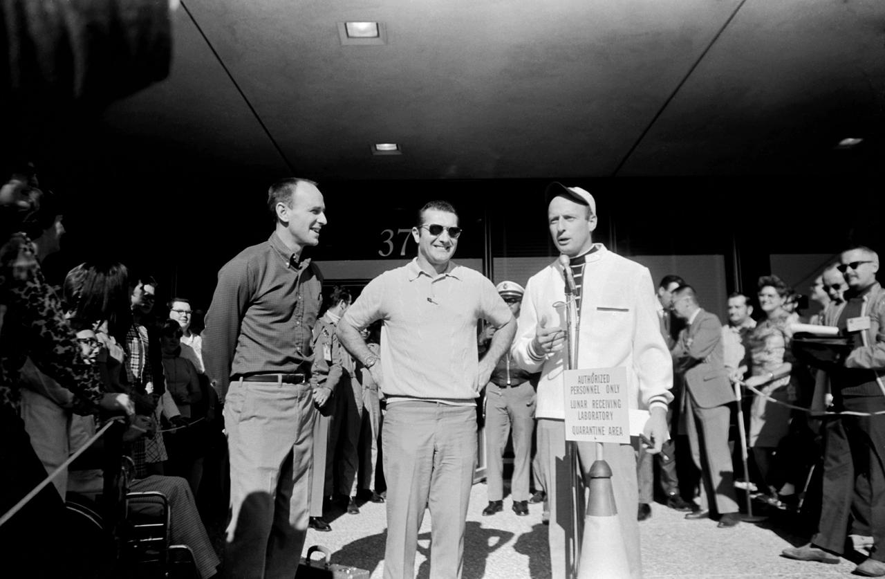 S69-62884 (10 Dec. 1969) --- Astronaut Charles Conrad Jr., commander of the Apollo 12 lunar landing mission, makes several remarks publicly in response to the welcome given him and other members of the Apollo 12 crew upon their release from post-mission isolation in the Manned Spacecraft Center's (MSC) Lunar Receiving Laboratory (LRL). Pictured with Conrad outside Building 37, which houses the LRL, are his fellow crewmembers for the Apollo 12 mission, astronauts Alan L. Bean (left), lunar module pilot; and Richard F. Gordon Jr. (center), command module pilot.