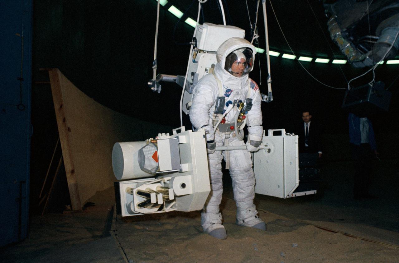 S70-24009 (19 Jan. 1970) --- Astronaut Fred W. Haise Jr., Apollo 13 lunar module pilot, trains for his scheduled April lunar space walk at the Manned Spacecraft Center (MSC).  Haise carries a training version of the Apollo Lunar Surface Experiments Package (ALSEP), while connected to a "Six Degrees of Freedom" simulator.  Out of frame is astronaut James A. Lovell Jr., commander, who will share the lunar extravehicular activity (EVA) with Haise.    EDITOR'S NOTE: In April 1970 the Apollo 13 Service Module (SM) experienced an explosion en route to the moon.  The three-man crew was forced to circumnavigate the moon and return to Earth.