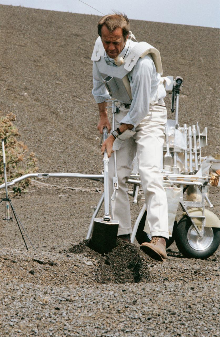 S70-34415 (April 1970) --- Astronaut Alan B. Shepard Jr., prime crew commander of the Apollo 14 mission, uses a trenching tool during a simulation of a traverse on the lunar surface. Members of the Apollo 14 prime and backup crews were in Hawaii to train for the extravehicular activity of their upcoming mission. Features of the terrain at Kapoho and other Hawaiian sites are very similar to those found on the lunar surface. A modular equipment transporter (MET), nicknamed the "Rickshaw" because of its appearance and method of propulsion, is behind Shepard, and a gnomon, one of the Apollo lunar hand tools (ALHT) is at extreme left.