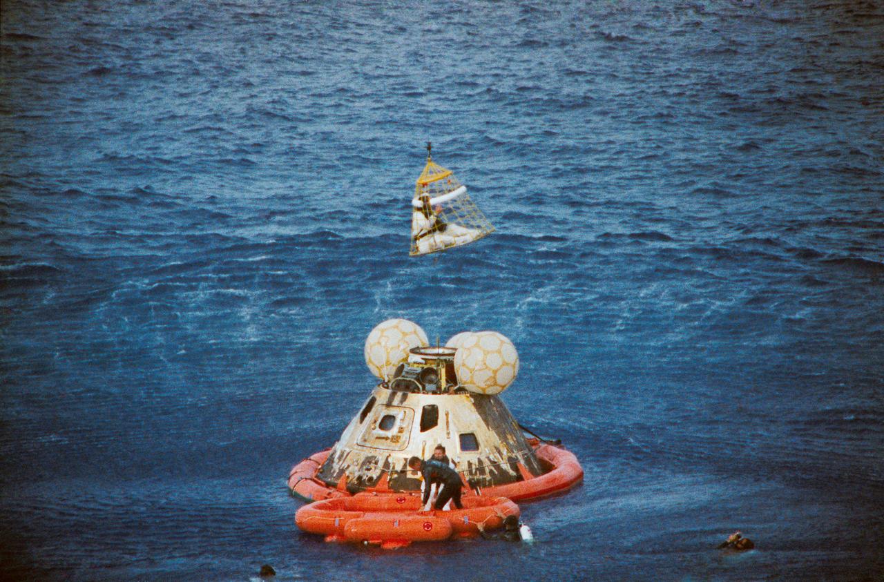 S70-35651 (17 April 1970) --- Astronaut John L. Swigert Jr., command module pilot, is lifted aboard a helicopter in a "Billy Pugh" net while astronaut James A. Lovell Jr., commander, awaits his turn. Astronaut Fred W. Haise Jr., lunar module pilot, is already aboard the helicopter. In the life raft with Lovell, and in the water are several U.S. Navy underwater demolition team swimmers, who assisted in the recovery operations. The crew was taken to the USS Iwo Jima, prime recovery ship, several minutes after the Apollo 13 spacecraft splashed down at 12:07:44 p.m. (CST), April 17, 1970.