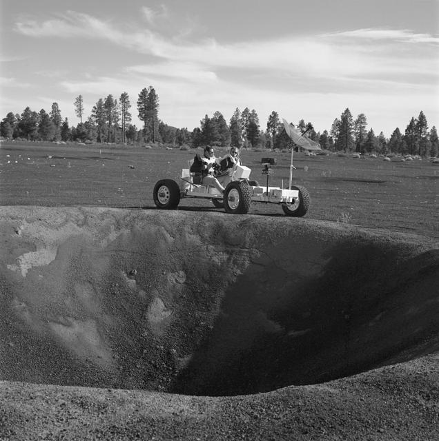 NASA image: Apollo 15 crewmen riding lunar roving vehicle simulator during geology trip