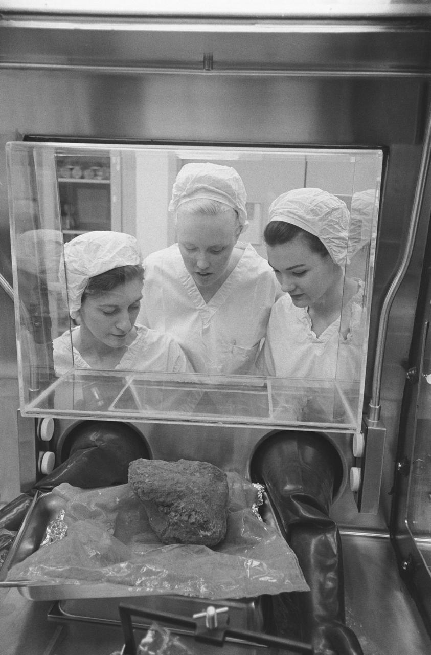 S71-21244 (24 Feb. 1971) --- Three Brown and Root/Northrop technicians in the Nonsterile Nitrogen Laboratory in the Lunar Receiving Laboratory (LRL) peer through glass at the much-discussed basketball size rock which Apollo 14 crewmen brought back from the Fra Mauro area of the moon. They are, left to right, Linda Tyler, Nancy L. Trent and Sandra Richards.