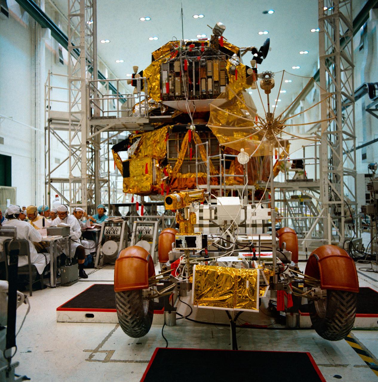 S71-30542 (21 April 1971) --- An overall view of the Apollo 15 Lunar Roving Vehicle (LRV) and the Lunar Module (LM) during simulations at the Kennedy Space Center (KSC). Astronauts David R. Scott, commander, and James B. Irwin, lunar module pilot, will man the LRV on the lunar surface during their August 1971 traverses. Rover 1 will permit the astronauts to cover a larger area of the moon for exploration and sample collecting than on previous missions.