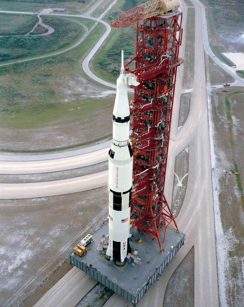 S71-33781 (11 May 1971) --- High angle view showing the Apollo 15 (Spacecraft 112/Lunar Module 10/Saturn 510) space vehicle on the way from the Vehicle Assembly Building (VAB) to Pad A, Launch Complex 39, Kennedy Space Center (KSC). The Saturn V stack and its mobile launch tower are atop a huge crawler-transporter. Apollo 15 is scheduled as the fourth manned lunar landing mission by the National Aeronautics and Space Administration (NASA). The crew men will be astronauts David R. Scott, commander; Alfred M. Worden, command module pilot; and James B. Irwin, lunar module pilot. While astronauts Scott and Irwin descend in the Lunar Module (LM) to explore the moon, astronaut Worden will remain with the Command and Service Modules (CSM) in lunar orbit.