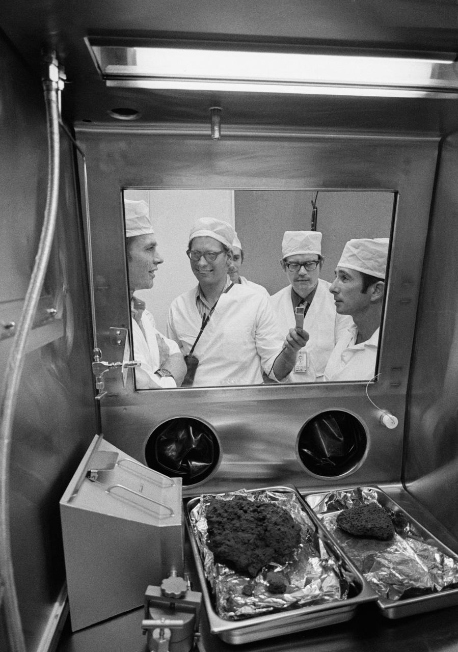 S71-43203 (9 Aug. 1971) --- Astronauts David R. Scott, left foreground, and James B. Irwin, right foreground, join the Manned Spacecraft Center's (MSC) geologists in getting first looks at some of the first Apollo 15 samples to be opened in the Non-Sterile Nitrogen Processing Line (NNPL) in the MSC Lunar Receiving Laboratory (LRL). Holding the microphone and making recorded tapes of the two Apollo 15 crew men's comments is Dr. Gary Lofgren. Partially obscured, near center of photo is Dr. William Phinney, and to his left is Dr. James W. Head.