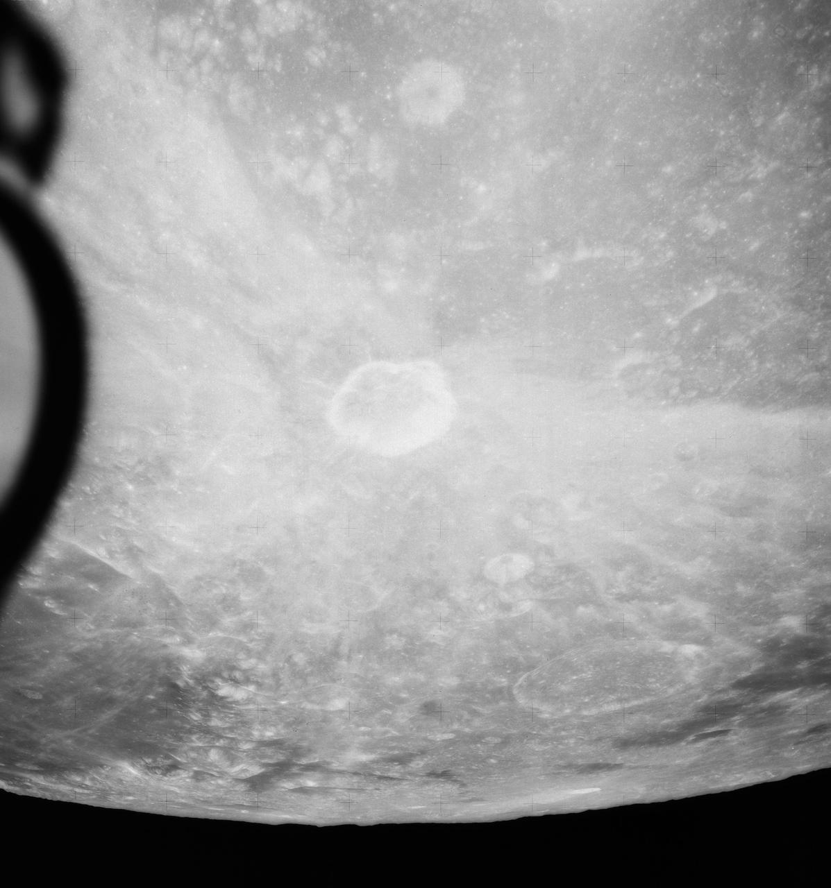 S71-44669 (31 July-2 Aug. 1971) --- An oblique view of the rayed crater Proclus on the lunar nearside, as photographed by the Fairchild metric camera in the SIM bay of the Apollo 15 Command and Service Modules (CSM) in lunar orbit. This view is looking north. The Sea of Crisis is at upper right. Proclus, which is 28 kilometers (16.58 statute miles) in diameter, is located at 47 degrees east longitude and 16 degrees north latitude. The Marsh of Sleep is at lower left. A small portion of the Sea of Tranquility can be seen at upper left. The crater Macrobius is located at upper left. The three-inch mapping camera was one of eight lunar orbital science experiments mounted in the SIM bay.