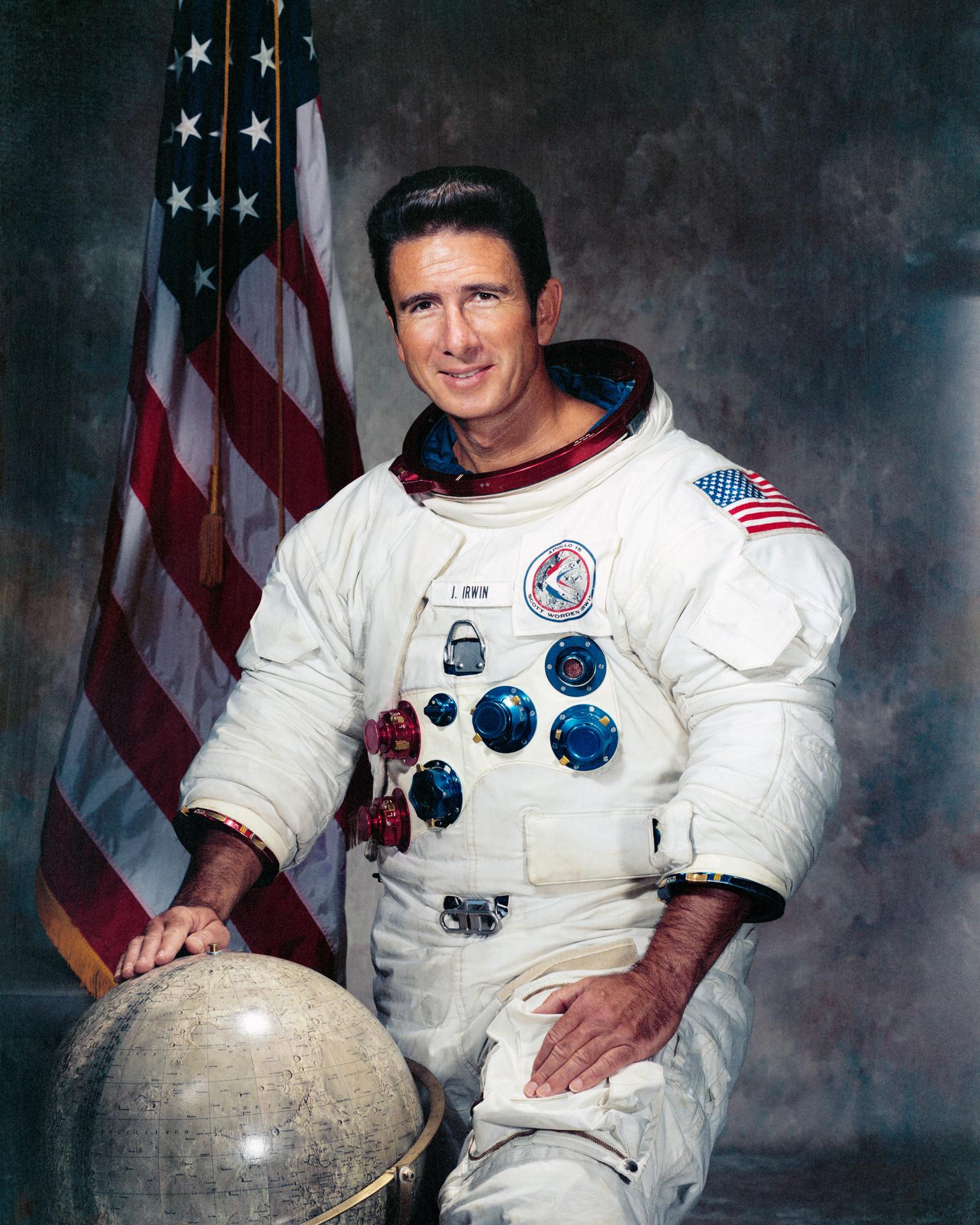 Portrait of James B. Irwin in white spaceship with globe