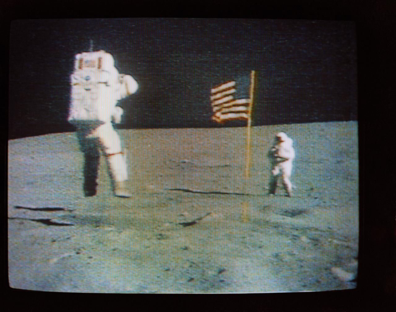S72-35611 (21 April 1972) --- Astronaut John W. Young, commander of the Apollo 16 lunar landing mission, leaps from the lunar surface as he salutes the U.S. flag, during the first Apollo 16 extravehicular activity (EVA) on the moon, as seen in this reproduction taken from a color television transmission made by the color television camera mounted on the Lunar Roving Vehicle (LRV). Astronaut Charles M. Duke Jr., lunar module pilot, is standing in the background. While astronauts Young and Duke descended in the Apollo 16 Lunar Module (LM) "Orion" to explore the Descartes highlands landing site on the moon, astronaut Thomas K. Mattingly II, command module pilot, remained with the Command and Service Modules (CSM) "Casper" in lunar orbit.