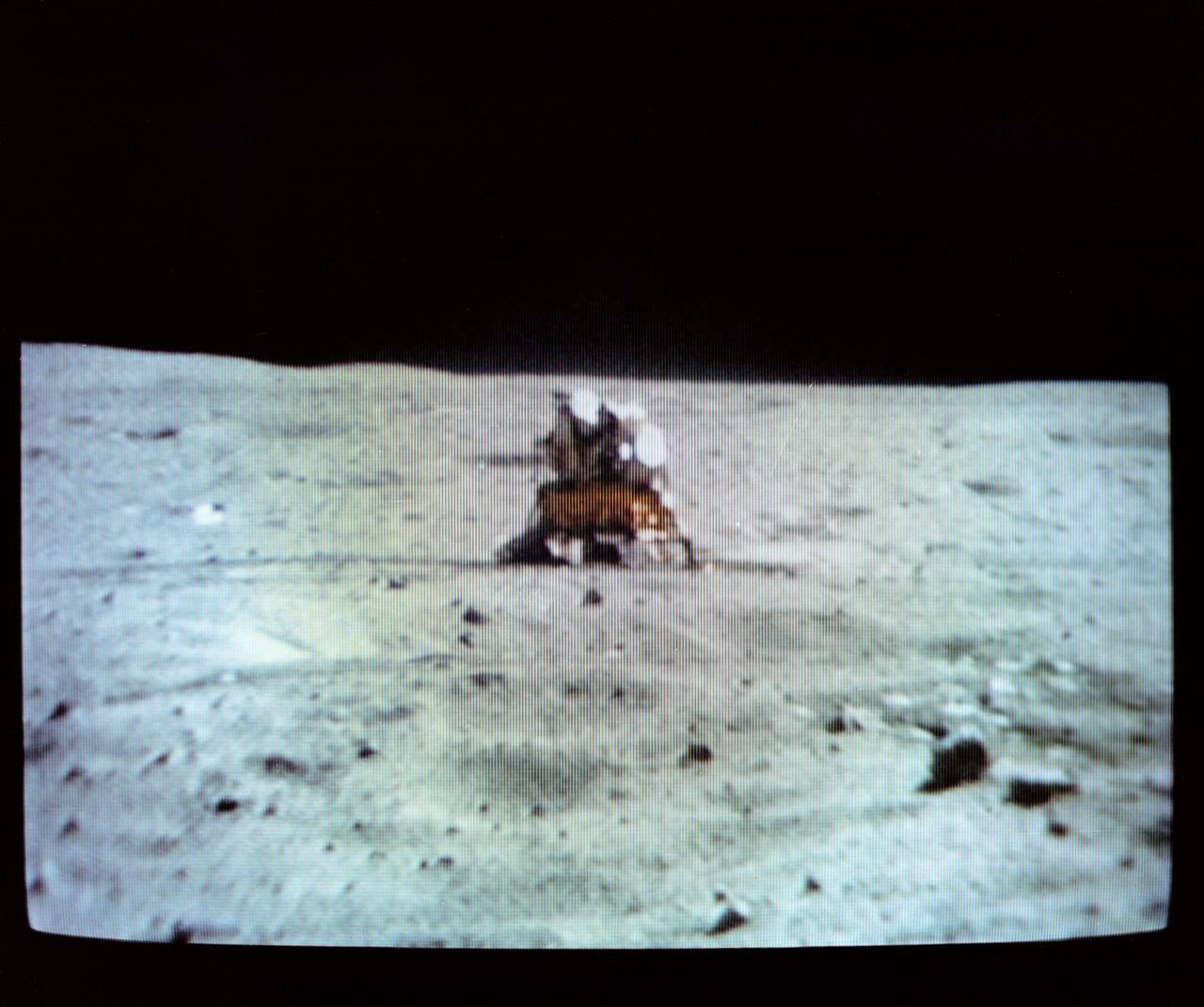 S72-35612 (22 April 1972) --- The Apollo 16 Lunar Module (LM) "Orion" dominates the lunar scene at the Descartes landing site, as seen in the reproduction taken from a color television transmission made by the TV camera mounted on the Lunar Roving Vehicle (LRV). Astronauts John W. Young, commander; and Charles M. Duke Jr., lunar module pilot; descended in the Apollo 16 LM to explore the Descartes highlands landing site on the moon. Astronaut Thomas K. Mattingly II, command module pilot, remained with the Command and Service Modules (CSM) "Casper" in lunar orbit. Note U.S. flag deployed on the left. This picture was made during the second Apollo 16 extravehicular activity (EVA).