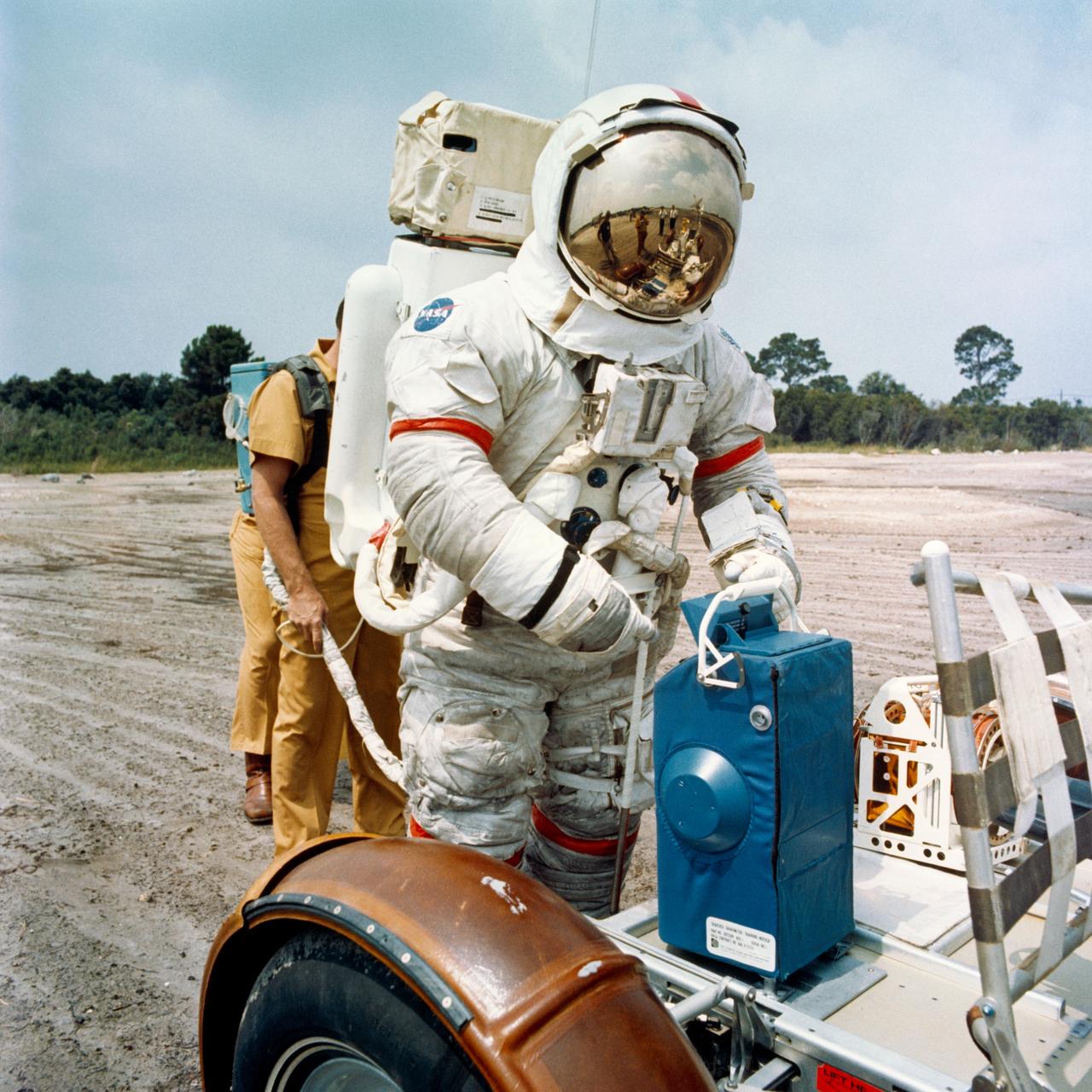 S72-44420 (8 June 1972) --- Astronaut Eugene A. Cernan, commander of the Apollo 17 lunar landing mission, prepares to remove a traverse gravimeter training mock-up from a Lunar Roving Vehicle for deployment during lunar surface extravehicular activity simulations at the Kennedy Space Center (KSC), Florida.