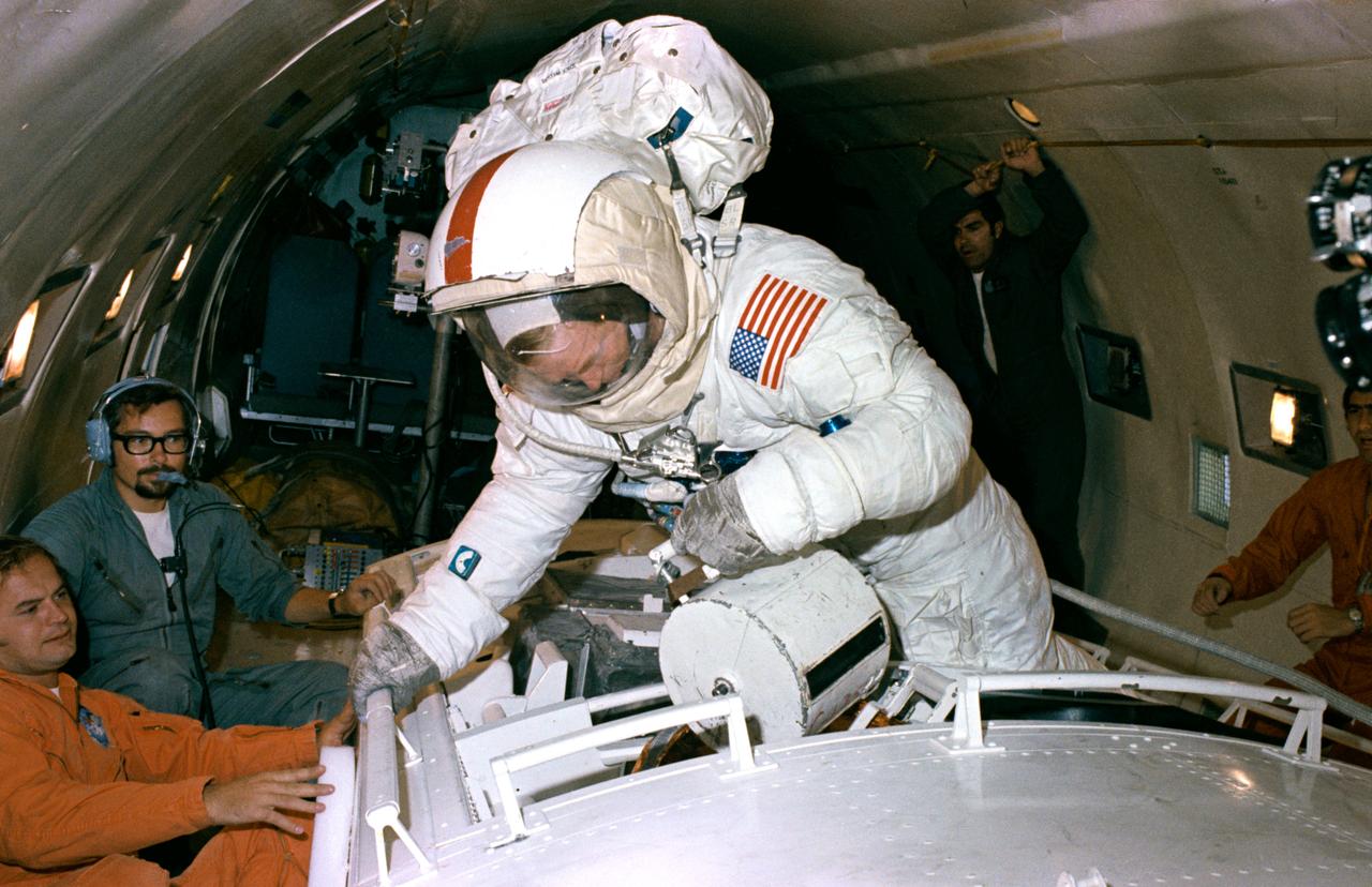 S72-50271 (September 1972) --- Astronaut Stuart A. Roosa, backup crew command module pilot of the Apollo 17 lunar landing mission, participates in extravehicular activity simulation training under zero-gravity conditions aboard a U. S. Air Force KC-135 aircraft. A mock-up of the Scientific Instrument Module (SIM) bay of the Apollo 17 Service Module is used in the exercise. Here, Roosa simulates retrieving the film cassette of the Mapping Camera from the SIM bay. Astronaut Ronald E. Evans, Apollo 17 prime crew command module pilot, is scheduled to receive film cassettes from the Mapping Camera, Panoramic Camera, and Lunar Sounder during Apollo 17 trans-Earth extravehicular activity.