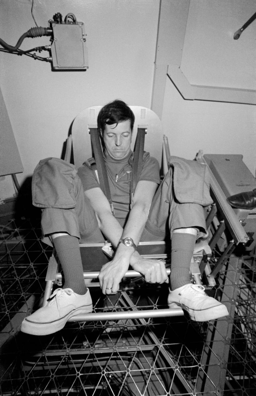 S73-20622 (March 1973) --- Scientist-astronaut Joseph P. Kerwin, science pilot of the first manned Skylab mission, demonstrates the Body Mass Measurement Experiment (M172) during Skylab training at the Johnson Space Center. Dr. Kerwin is in the work and experiments area of the crew quarters of the Skylab Orbital Workshop (OWS) trainer at JSC. The M172 experiment will demonstrate body mass measurement in a null gravity environment, validate theoretical behavior of this method, and support those medical experiments for which body mass measurements are required. The data to be collected in support of M172 are: preflight calibration of the body mass measurement device and measurements of known masses up to 100 kilograms (220 pounds) three times during each Skylab mission. The device, a spring/flexure pivot-mounted chair, will also be used for daily determination of the crewmen?s weight, which will be manually logged and voice recorded for subsequent telemetered transmission. Photo credit: NASA