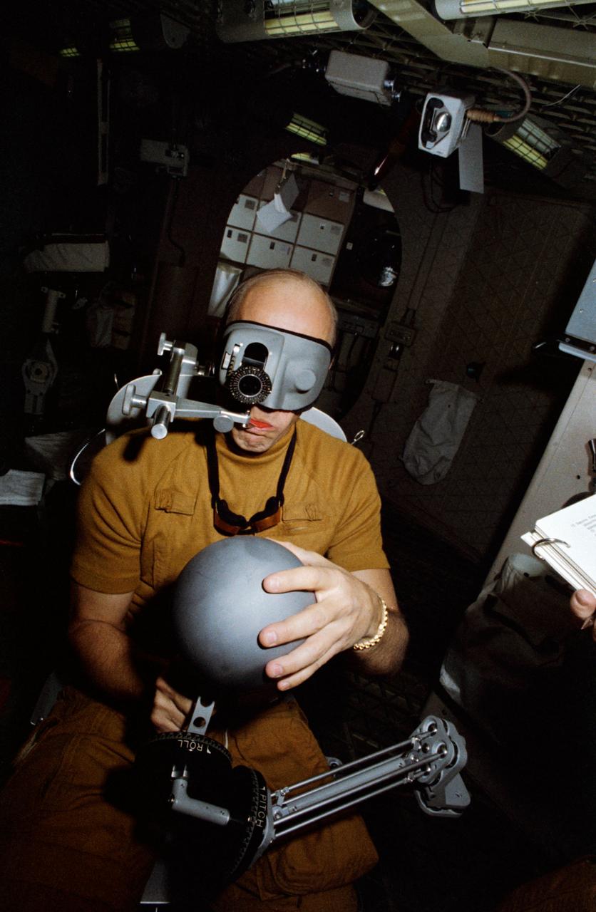 S73-20695 (1 March 1973) --- Astronaut Charles Conrad Jr., commander of the first manned Skylab mission, checks out the Human Vestibular Function, Experiment M131, during Skylab training at Johnson Space Center. Conrad is in the work and experiments compartment of the crew quarters of the Skylab Orbital Workshop (OWS) trainer at JSC. The reference sphere with a magnetic rod is used by the astronaut to indicate body orientation non-visually. The litter chair in which he is seated can be rotated by a motor at its base or, when not being rotated, can tilt forward, backward or to either side. Photo credit: NASA