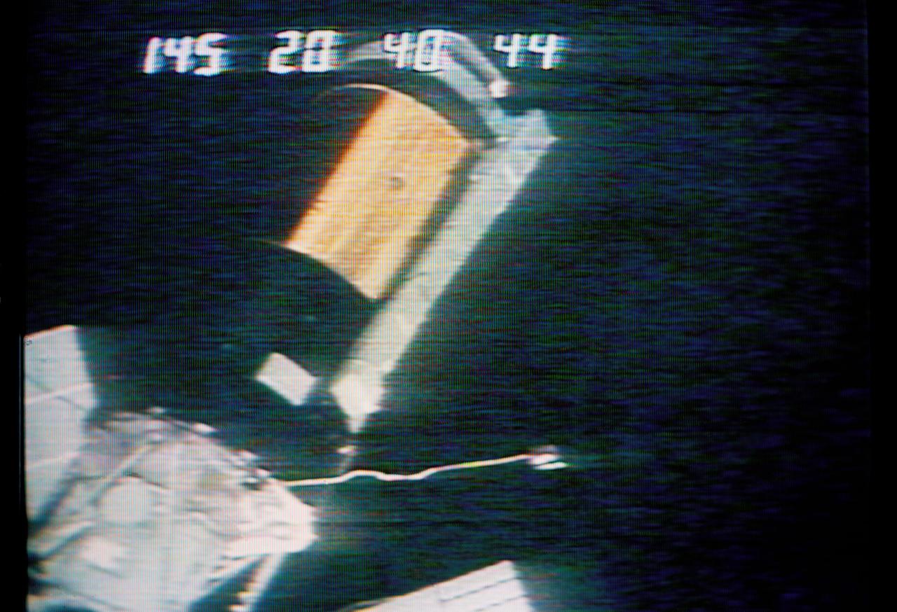 S73-26738 (25 May 1973) --- A close-up view of the Skylab 1 space station cluster can be seen in this reproduction taken from a color television transmission made by a TV camera aboard the Skylab 2 Command Module during its ?fly-around? inspection of the cluster.  The numbers across the top of the picture indicate the Skylab 1 ground lapse time. Note the missing portion of the micrometeoroid shield on the Orbital Workshop. The shield area was reported to be solid gold by the Skylab 2 crewmen. A cable appears to be wrapped around the damaged OWS solar array system wing. The crewmen reported that the other OWS solar panel was completely gone, with only tubes and wiring sticking out. One of the discone antennas extends out form the Airlock Module. The Multiple Docking Adapter is in the lower left corner of the picture. A portion of a solar panel on the Apollo Telescope Mount is visible at the bottom and at the left edge. In their ?fly around? inspection the crewmen noted that portions of the micrometeoroid shield had slid back underneath the OWS solar wing. Photo credit: NASA