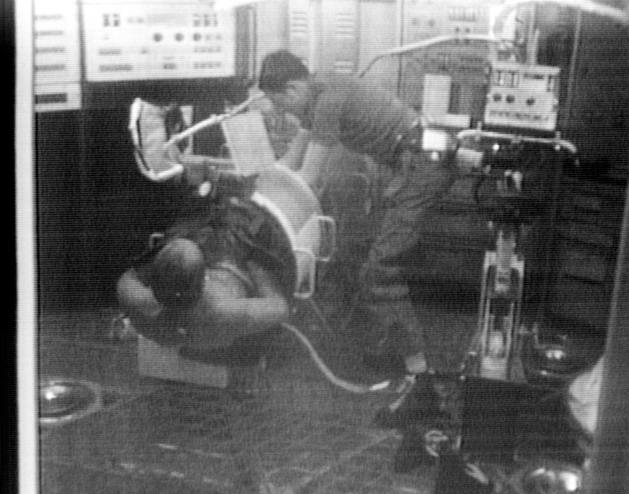 S73-27707 (9 June 1973) --- Astronaut Charles Conrad Jr., Skylab 2 commander, serves as test subject for the Lower Body Negative Pressure (MO92) Experiment, as seen in this reproduction taken from a color television transmission made by a TV camera aboard the Skylab 1/2 space station cluster in Earth orbit. Scientist-astronaut Joseph P. Kerwin, Skylab 2 science pilot, assists Conrad into the LBNP device. Kerwin served as monitor for the experiment. The purpose of the MO92 experiment is to provide information concerning the time course of cardiovascular adaptation during flight, and to provide inflight data for predicting the degree of orthostatic intolerance and impairment of physical capacity to be expected upon return to Earth environment. The data collected in support of MO92 blood pressure, heart rate, body temperature, vectorcardiogram, LBNPD pressure, leg volume changes, and body weight. Photo credit: NASA