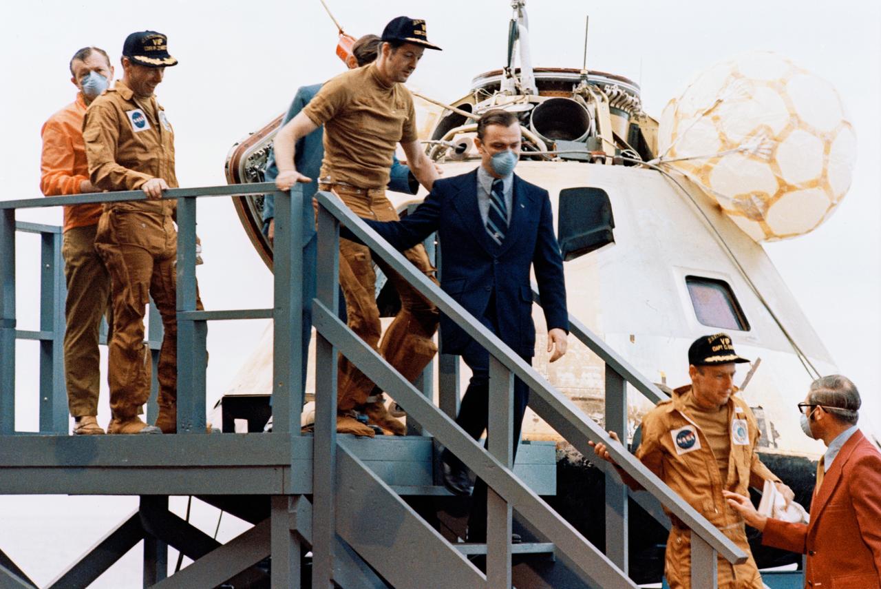 S73-29141 (22 June 1973) --- The three Skylab 2 crewmen arrive on the deck of the prime recovery ship, USS Ticonderoga, following the successful splashdown of the Skylab 2 Command Module about 835 miles southwest of San Diego, California. Leading down the steps is astronaut Charles Conrad Jr., commander, followed by scientist-astronaut Joseph P. Kerwin, science pilot, and astronaut Paul J. Weitz, pilot. Recovery and medical personnel walk down the steps with the astronauts. The crewmen remained inside the spacecraft (seen in background) until it was hoisted aboard the recovery ship. Conrad, Kerwin and Weitz had just completed a 28-day stay with the Skylab 1 space station in Earth orbit conducting numerous medical, scientific and technological experiments. Photo credit: NASA