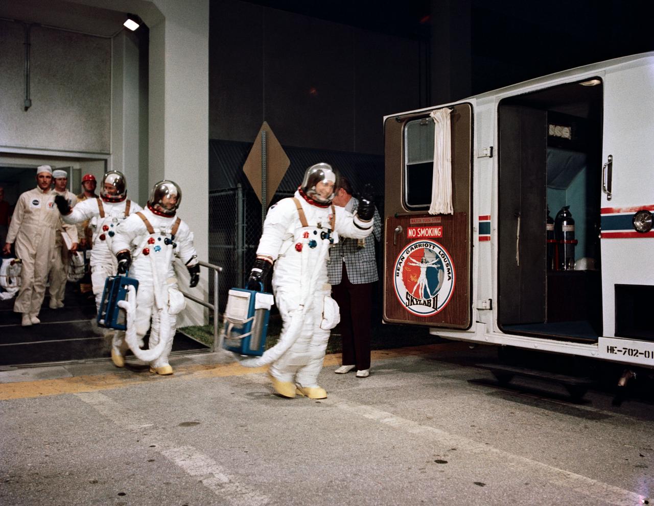 S73-31801 (28 July 1973) --- The three crewmen of the second manned Skylab mission (Skylab 3) leave the Manned Spacecraft Operations Building at the Kennedy Space Center on the morning of the Skylab 3 launch. Leading is astronaut Alan L. Bean, commander; followed by scientist-astronaut Owen K. Garriott, science pilot; and astronaut Jack R. Lousma, pilot. They entered the special van which carried them to Pad B at KSC?s Launch Complex 39 where the Skylab 3/Saturn 1B space vehicle awaited them. The Skylab 3 liftoff was at 7:11 a.m. (EDT), Saturday, July 28, 1973. The three astronauts were scheduled to spend 59 days at the Skylab space station in Earth orbit. Photo credit: NASA