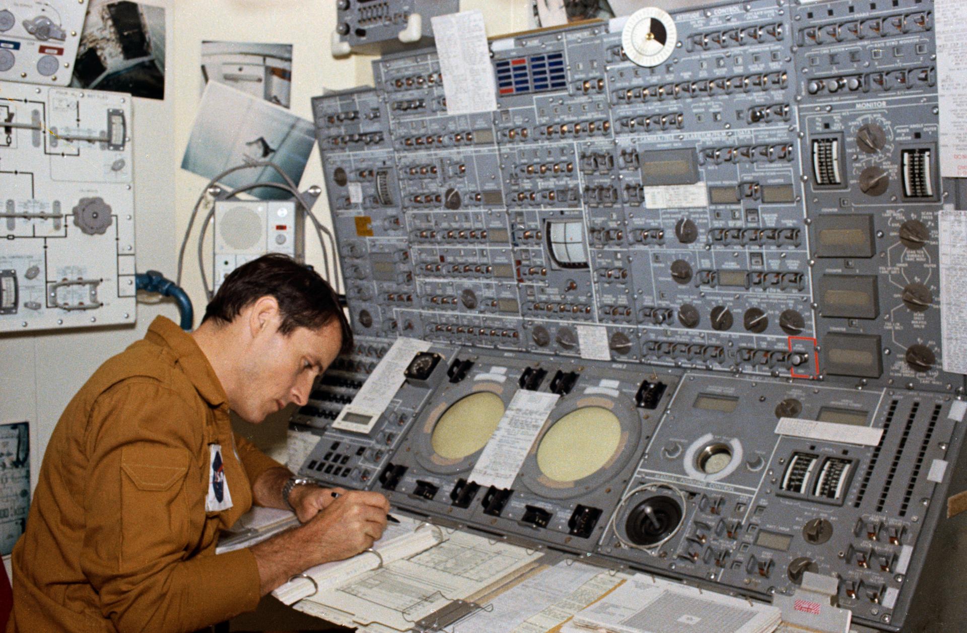 Ed Gibson reads a manual at a mockup of the the Apollo Telescope Mount's control panel