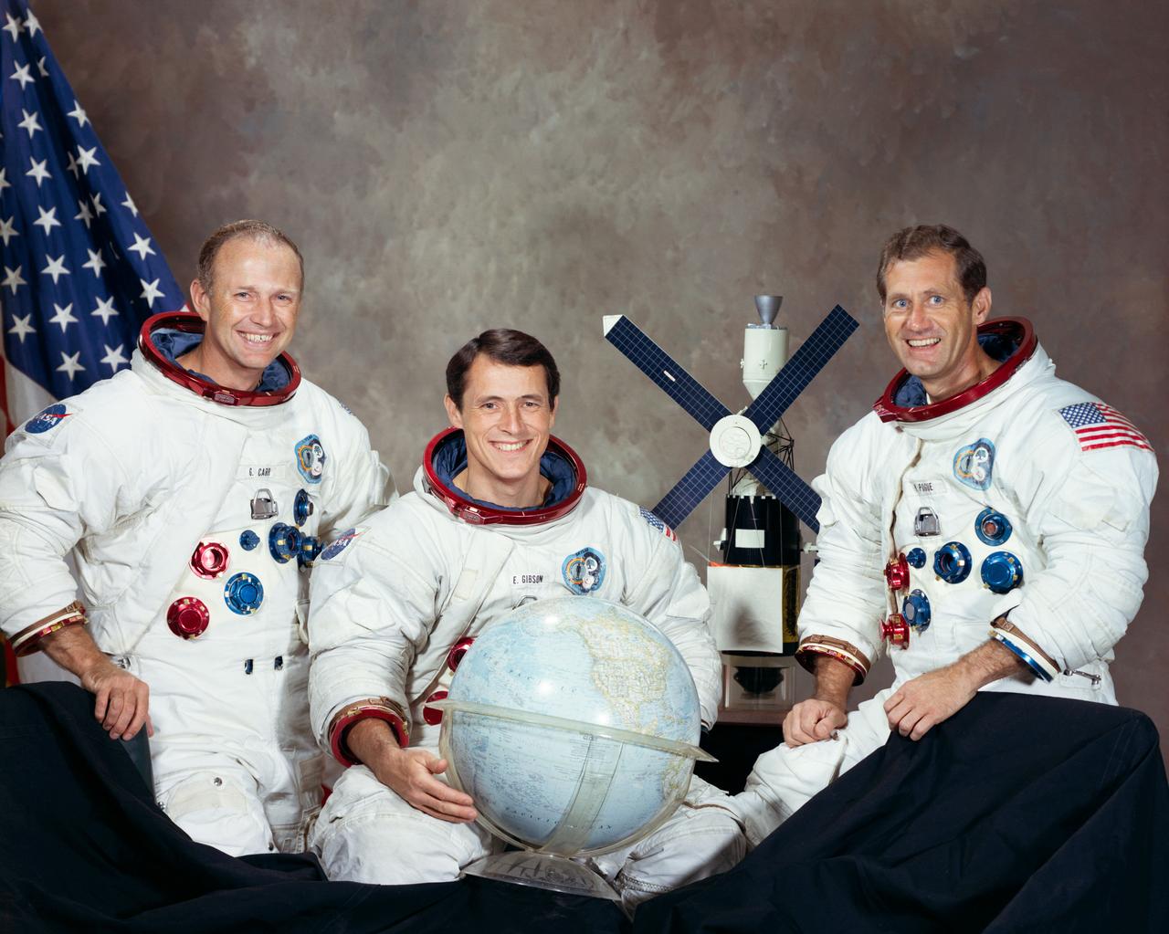 S73-33206 (August 1973) --- These three men are the prime crew for the Skylab 4 mission. Pictured in their Skylab spacesuits with a globe and a model of the Skylab space station are, left to right, astronaut Gerald P. Carr, commander; scientist-astronaut Edward G. Gibson, science pilot; and astronaut William R. Pogue, pilot. Photo credit: NASA