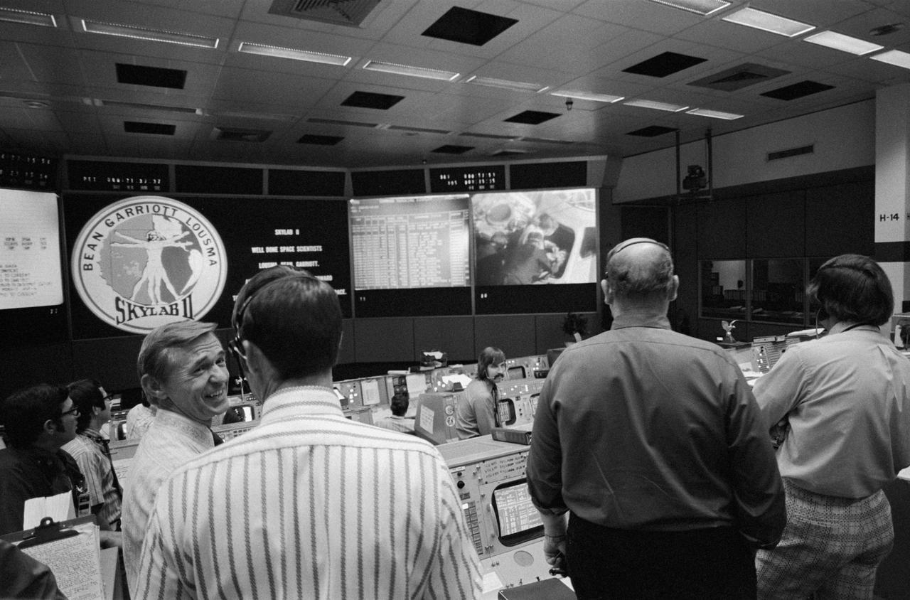 S73-34553 (25 Sept. 1973) --- Skylab flight directors (foreground) and flight controllers (background) view the large screen in the Mission Operations Control Room (MOCR) in the Mission Control Center (MCC) at JSC during recovery operations of the second manned Skylab mission. From left to right in the foreground are flight directors Charles R. Lewis, Donald R. Puffy, Phillip Shaffer and Neil B. Hutchinson. The Skylab 3 crewmen were preparing to egress the spacecraft aboard the USS New Orleans. Television cameras aboard the New Orleans recorded post-recovery activity. Photo credit: NASA