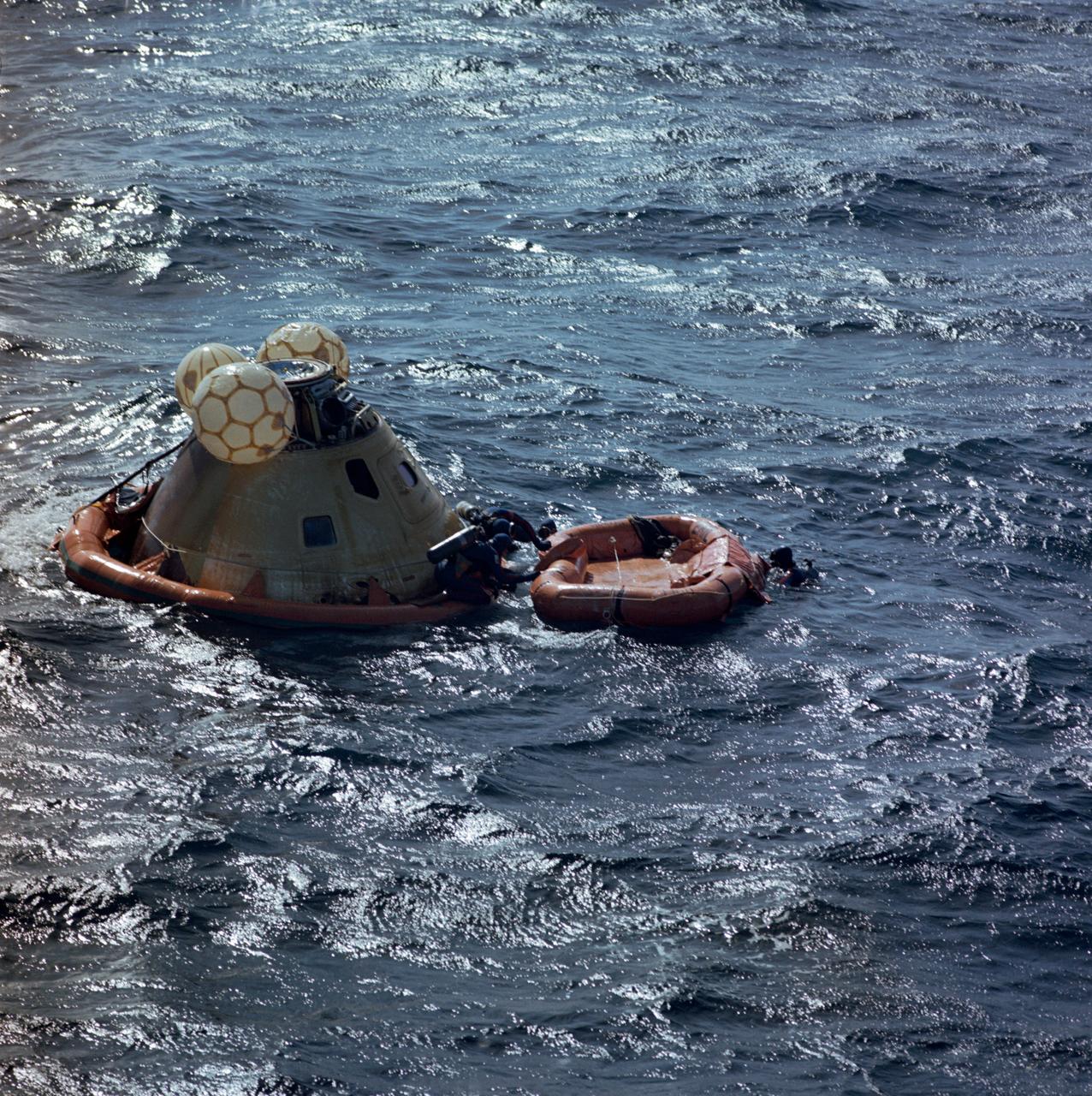 S73-36401 (25 Sept. 1973) --- A team of U.S. Navy swimmers assists with the recovery of the Skylab 3 Command Module following its splashdown in the Pacific Ocean about 230 miles southwest of San Diego, California. The swimmers had just attached a flotation collar to the spacecraft to improve its buoyancy. Aboard the Command Module were astronauts Alan L. Bean, Owen K. Garriott and Jack R. Lousma, who had just completed a successful 59-day visit to the Skylab space station in Earth orbit. Minutes later the Command Module with the three crewmen still inside was hoisted aboard the prime recovery ship, the USS New Orleans. Photo credit: NASA
