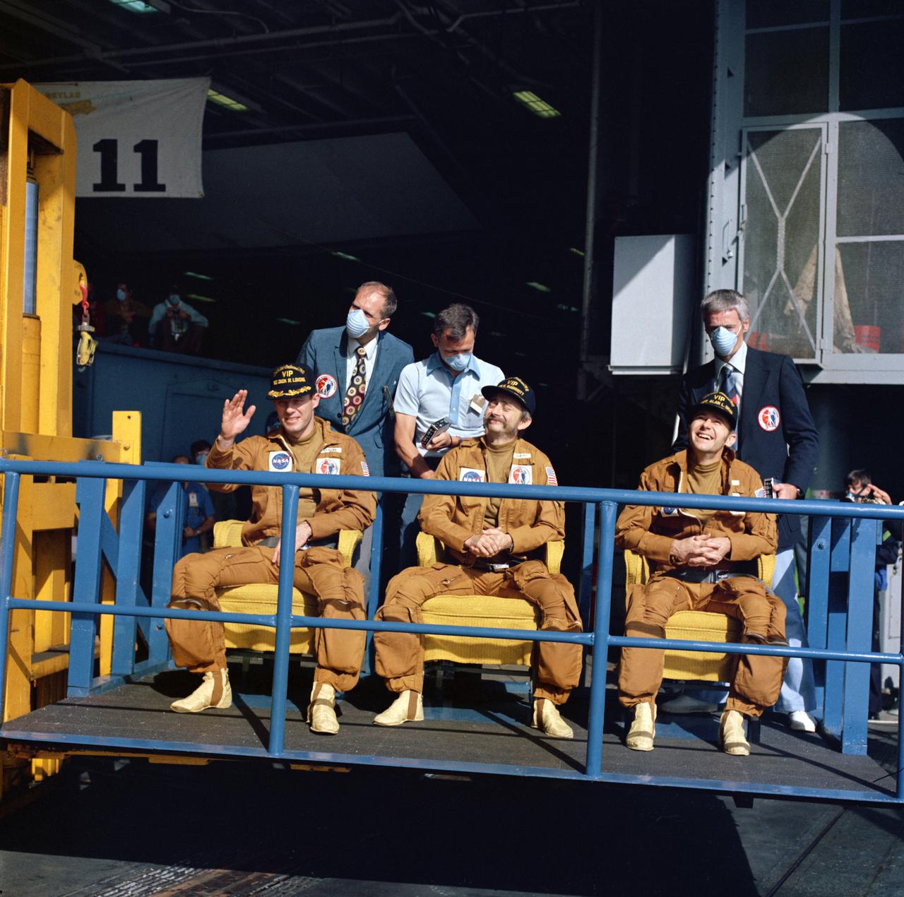S73-36451 (25 Sept. 1973) --- The three crewmen of the Skylab 3 mission are seen aboard the prime recovery ship, USS New Orleans, following their successful 59-day visit to the Skylab space station in Earth orbit. They are, left to right, astronaut Jack R. Lousma, pilot; scientist-astronaut Owen K. Garriott, science pilot; and astronaut Alan L. Bean, commander. The Skylab 3 Command Module with the three crewmen aboard splashed down in the Pacific about 230 miles southwest of San Diego, California. They are seated atop a platform of a fork-lift dolly. Recovery support personnel are wearing face masks to prevent exposing the crewmen to disease. Photo credit: NASA
