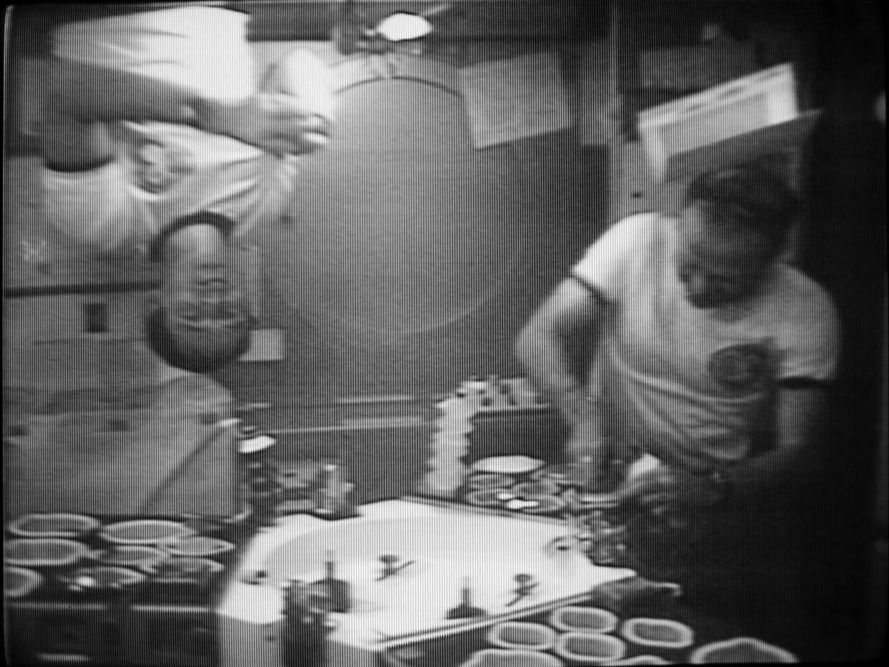 S73-37650 (28 Nov. 1973) --- Astronaut Gerald P. Carr, right, Skylab 4 commander, enjoys a meal aboard the orbiting Skylab space station in this photographic reproduction from a television of Nov. 28, 1973. Scientist-astronaut Edward G. Gibson, science pilot for the third manned Skylab flight, demonstrates the zero-gravity environment by turning upside. The two crewmen were joined by astronaut William R. Pogue, pilot, for the evening meal. The food station is in the wardroom of the Crew Quarters in the Orbital Workshop (OWS). Photo credit: NASA