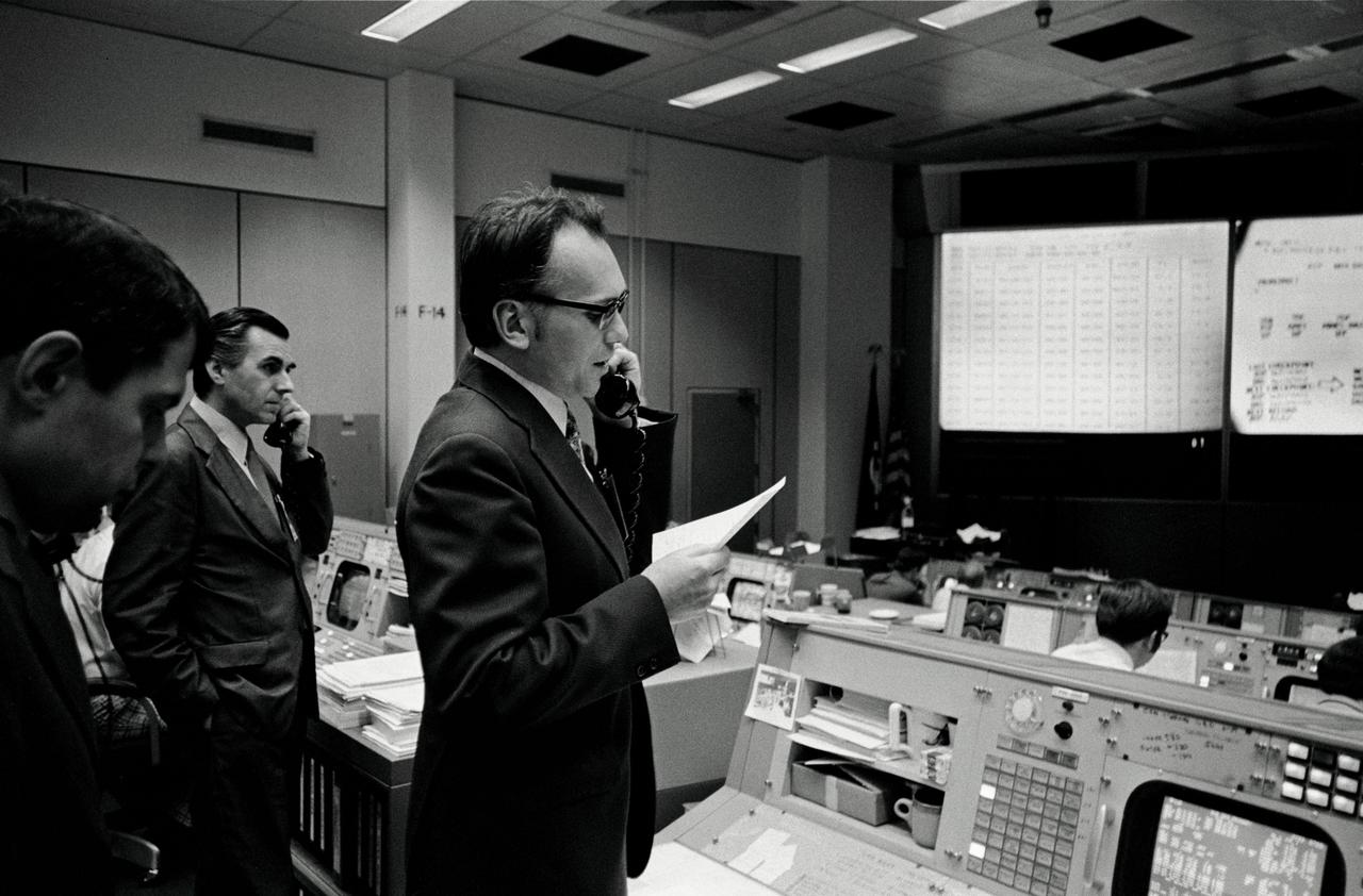 S74-15064 (28 Dec. 1973) --- Dr. Lubos Kohoutek, discoverer of the Comet Kohoutek, is seen in the Mission Operations Control Room in the Mission Control Center during a visit to the Johnson Space Center. He is talking over a radio-telephone with the Skylab 4 crewmen in the Skylab space station in Earth orbit. Professor Kohoutek, a well-known Czechoslovakian astronomer who works at the Hamburg Observatory in West Germany, discussed the comet with astronauts Gerald P. Carr, Edward G. Gibson and William R. Pogue. One of the major objectives of the Skylab 4 mission is to monitor the passing of the Comet Kohoutek. Dr. Zdenek Sekania, who accompanied Dr. Kohoutek on the visit to JSC, is on the telephone in the left background. Dr. Sekania is with the Smithsonian Observatory in Cambridge, Massachusetts. Photo credit: NASA
