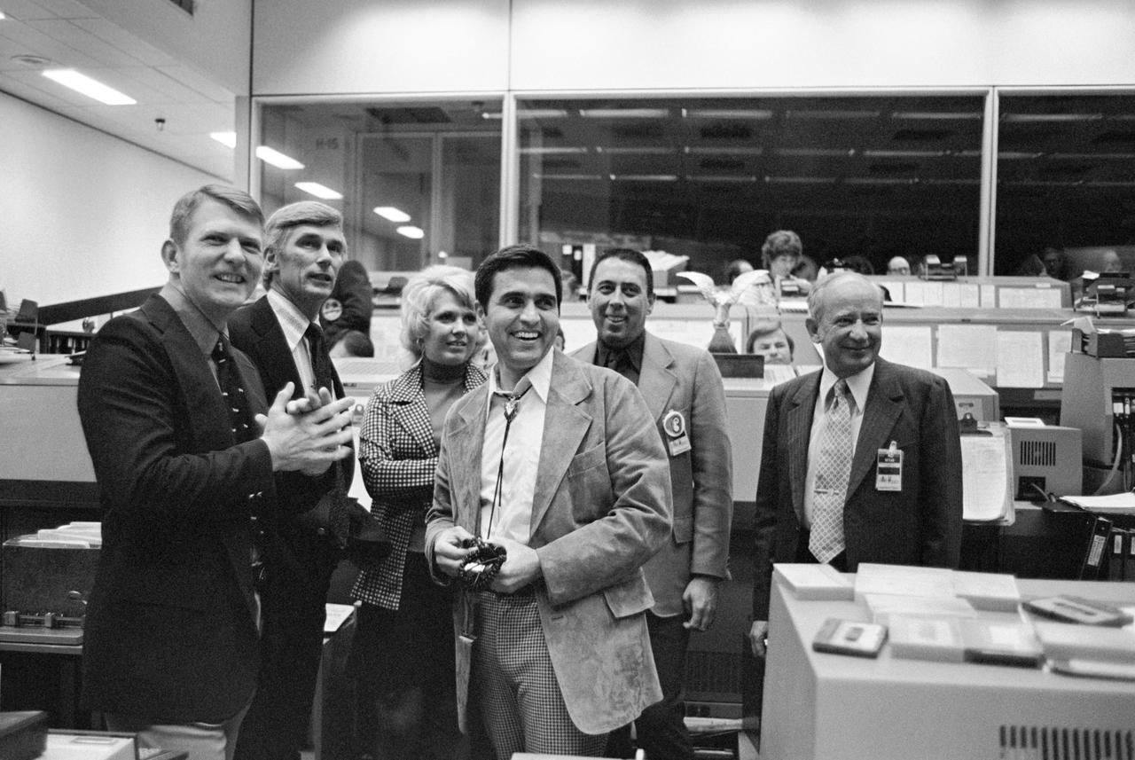 S74-15520 --- Left to right Gene Kranz, Gene Cernan, Karla Garnuch, Harrison Schmitt, George Abbey, and Sigurd A. Sjoberg watching the dedication of the Apollo 17 flag to the Mission Control Center. Photo credit: NASA