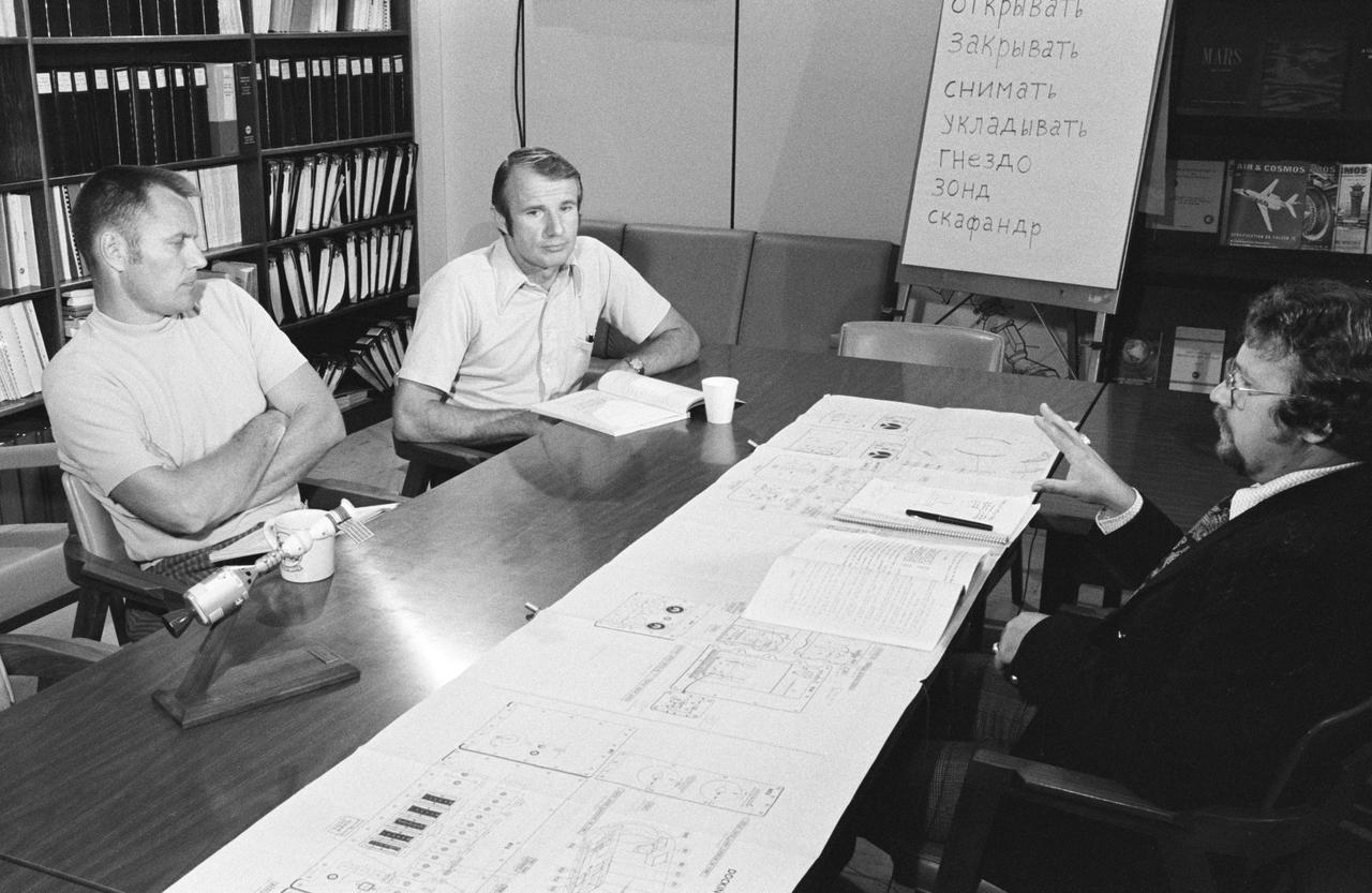 S74-23117 (6 June 1974) --- Two astronauts associated with the joint U.S.-USSR Apollo-Soyuz Test Project receive instructions in the Russian language during ASTP activity at the Johnson Space Center. They are Robert F. Overmyer, a member of the support team of the American ASTP crew, who is seated at left; and Vance D. Brand (center), the command module pilot of the American ASTP prime crew. The instructor is Anatoli Forestanko.